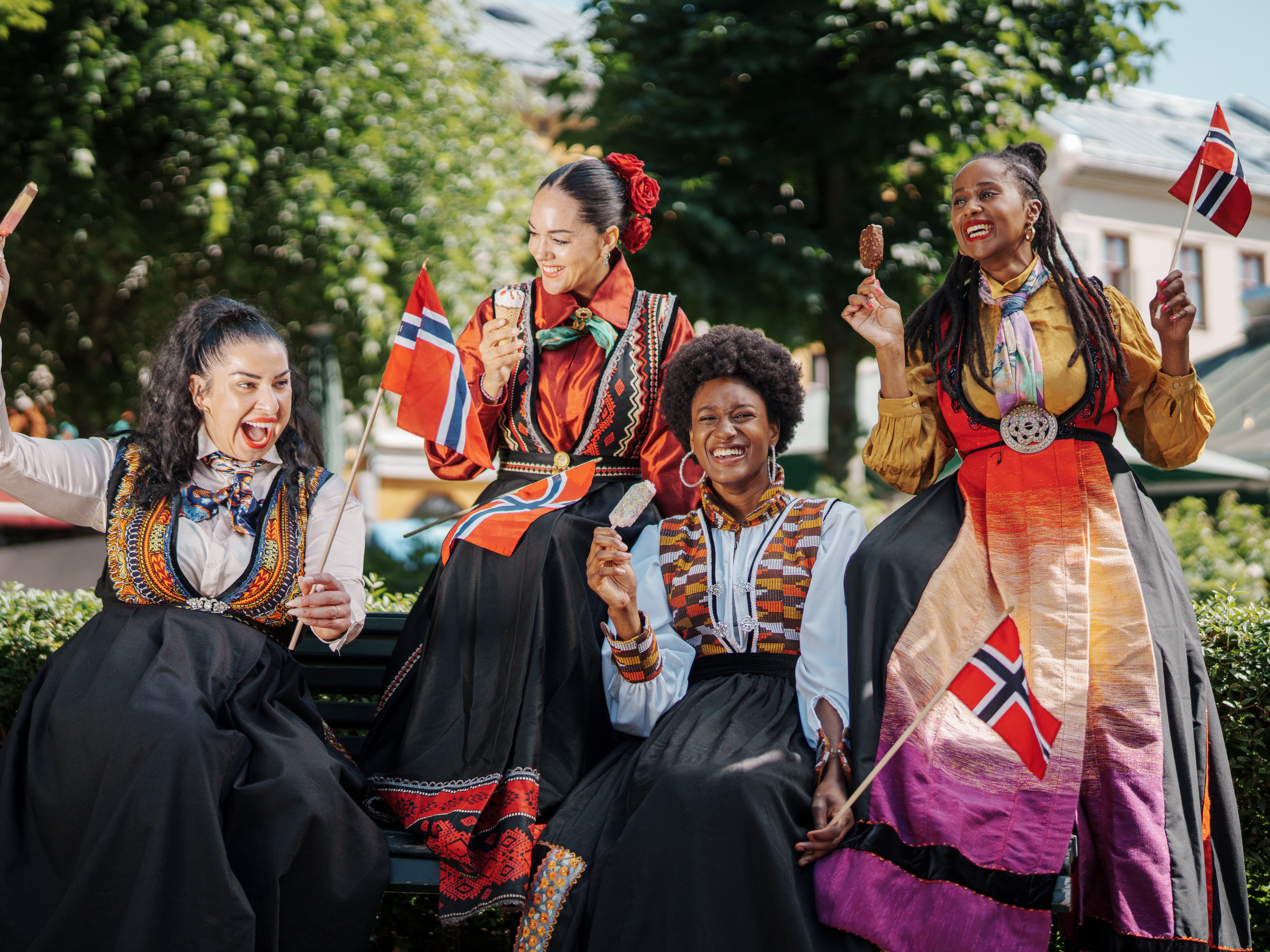 Four women in inclusive festive costumes.