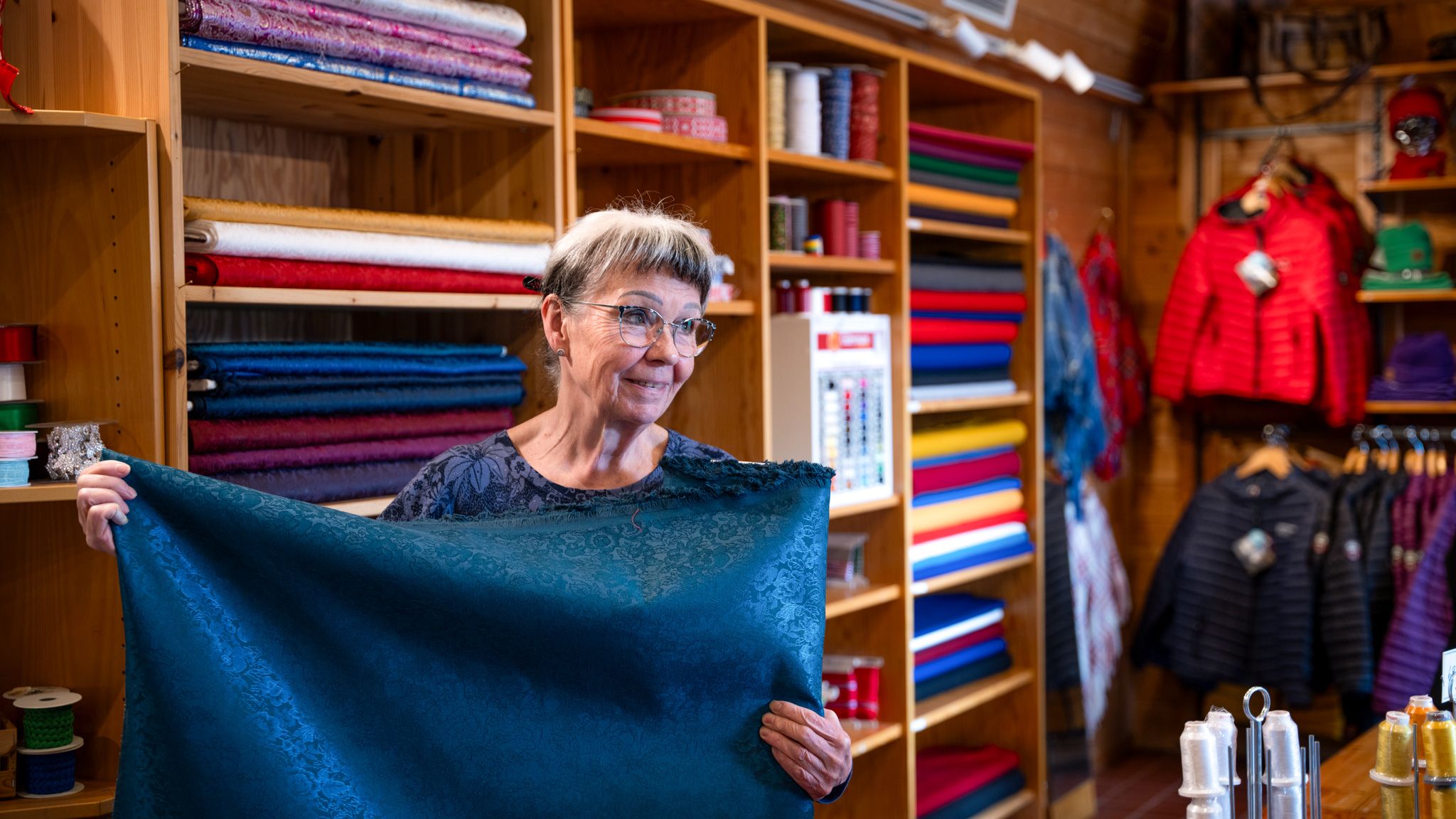 Kirsti Gulsrud showing off fabrics that are for sale at Sapmi Park in Karasjok