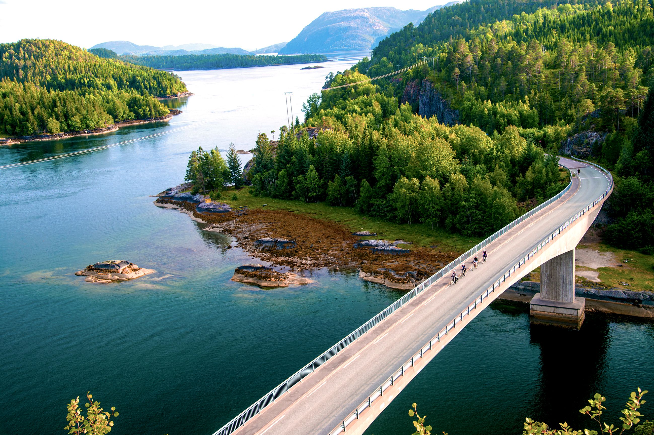 Landevejsryttere cykler over en bro på Namdalskysten i Trøndelag, Norge