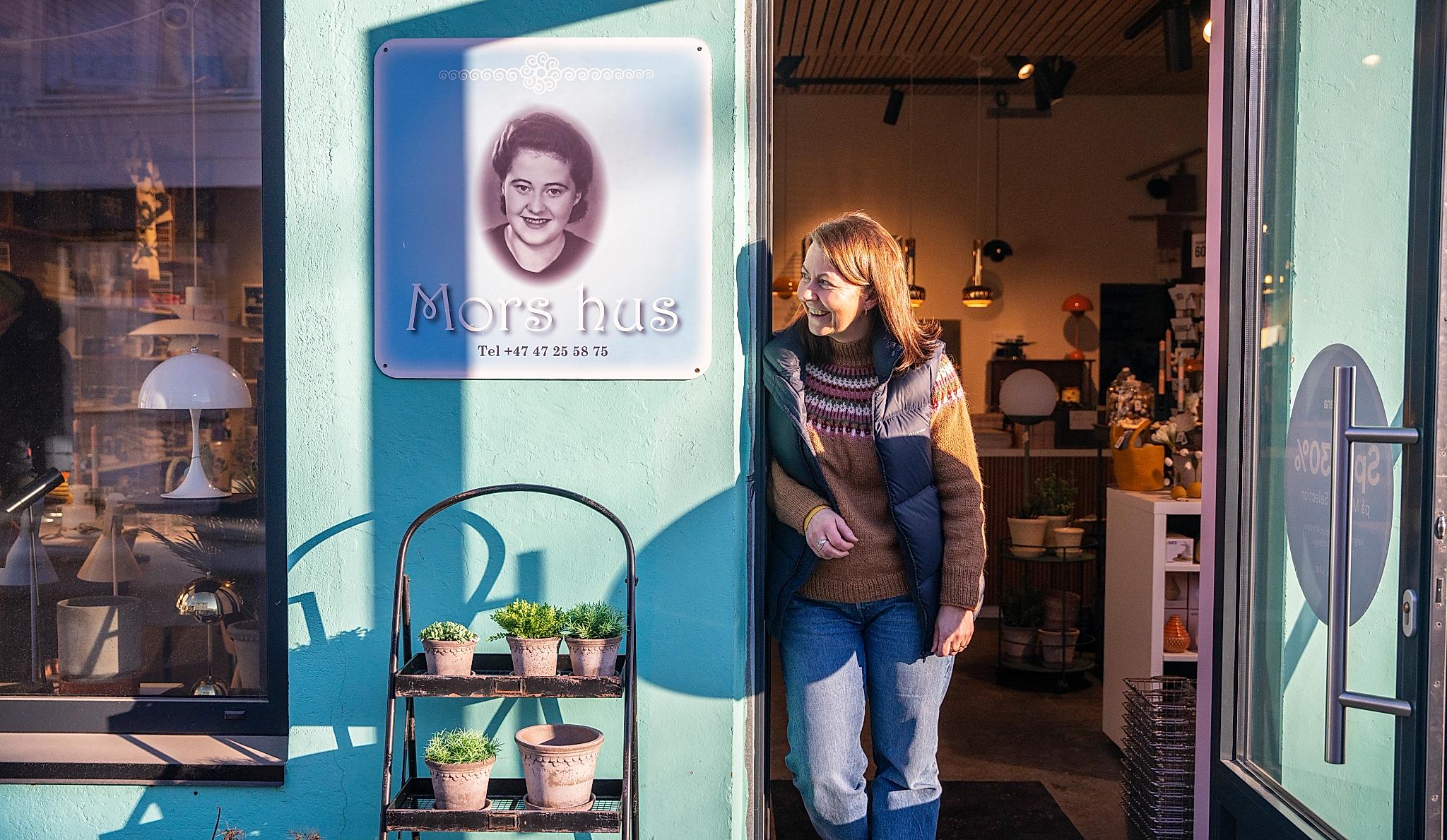 En kvinne som ser ut av døren på en butikk
