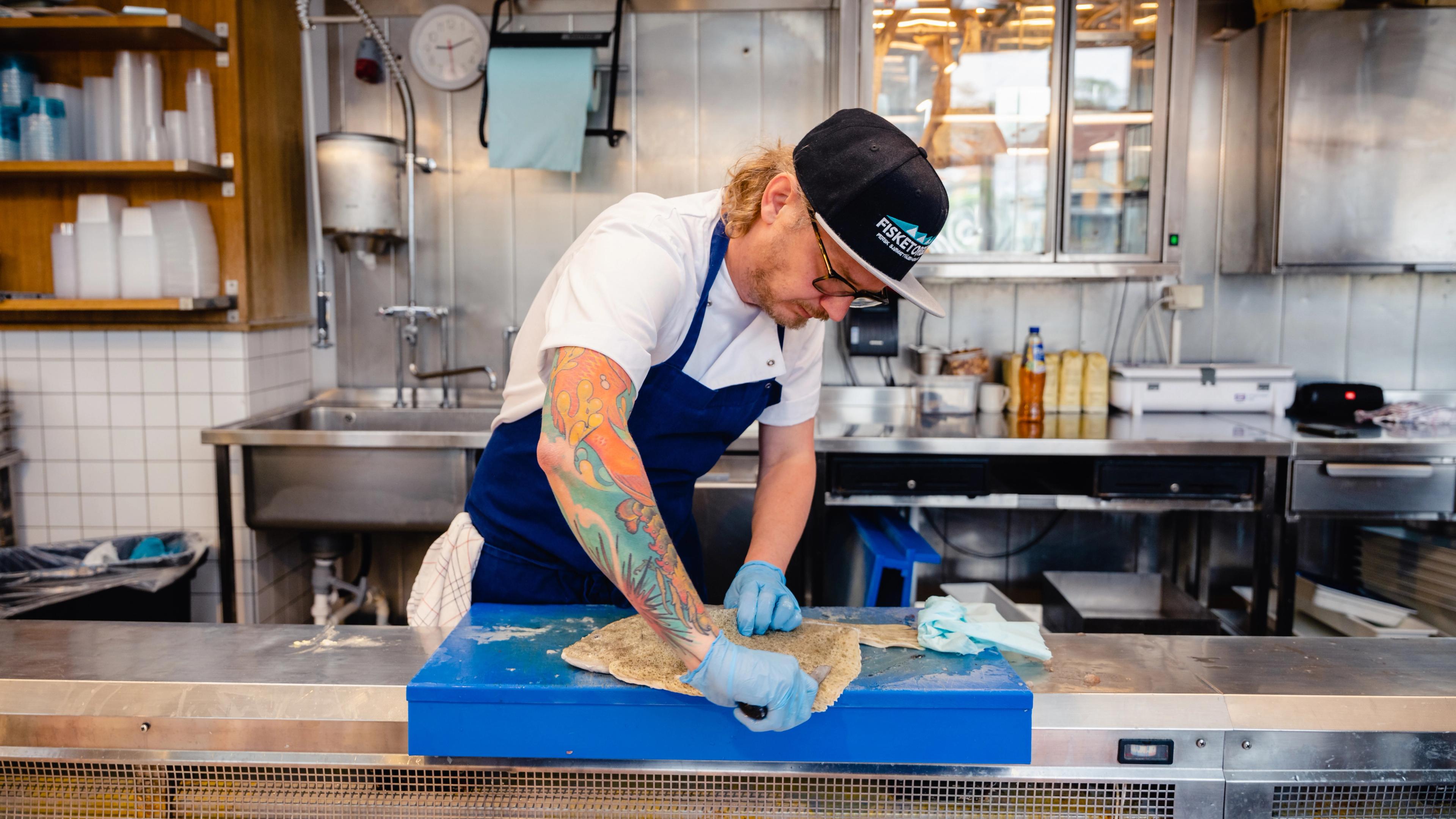 Karl Erik fileting fish at Fisketorget restaurant in Stavanger, Fjord Norway.