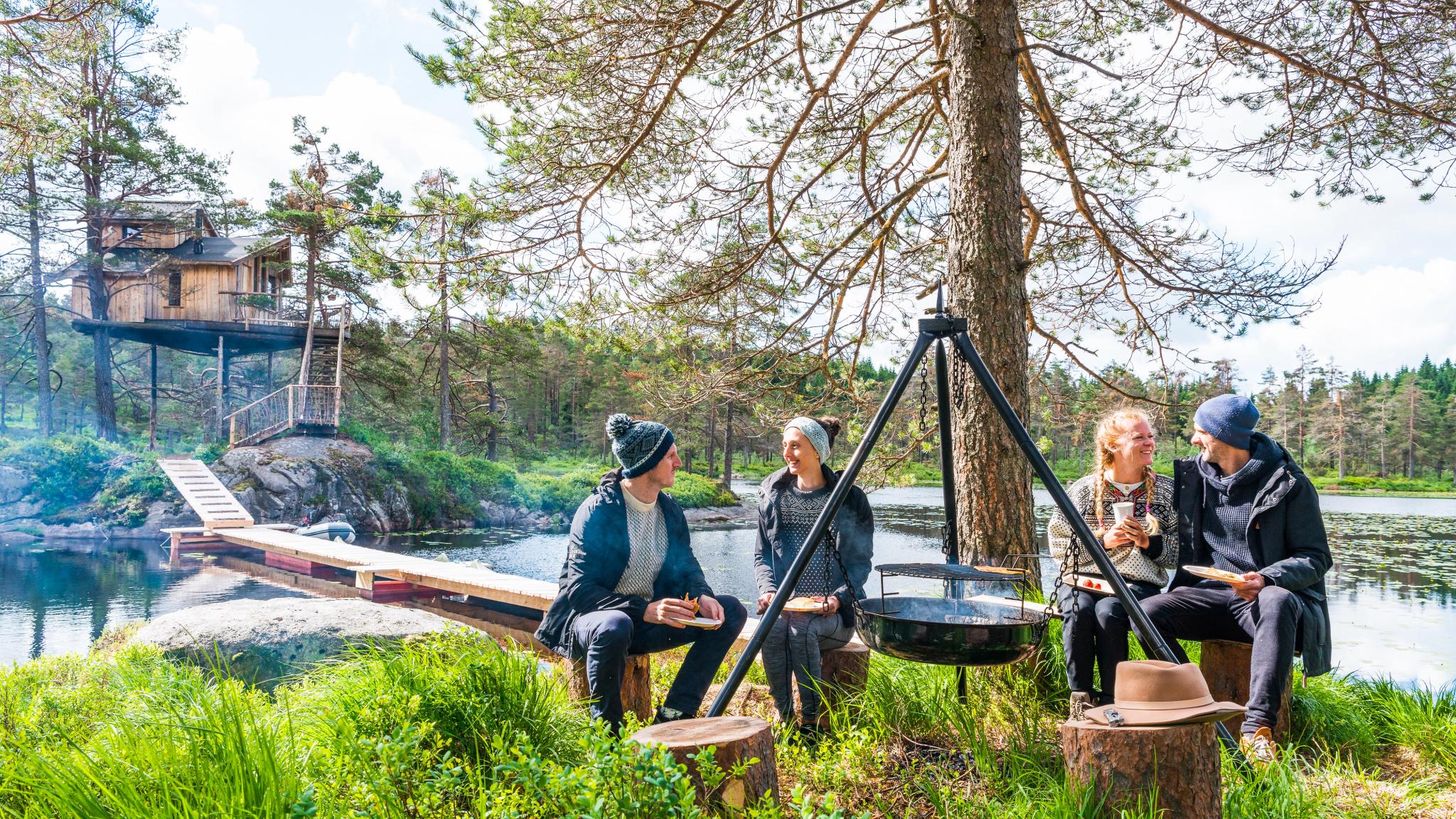 Friends eating around a bonfire at Fiddan in Lyngdal