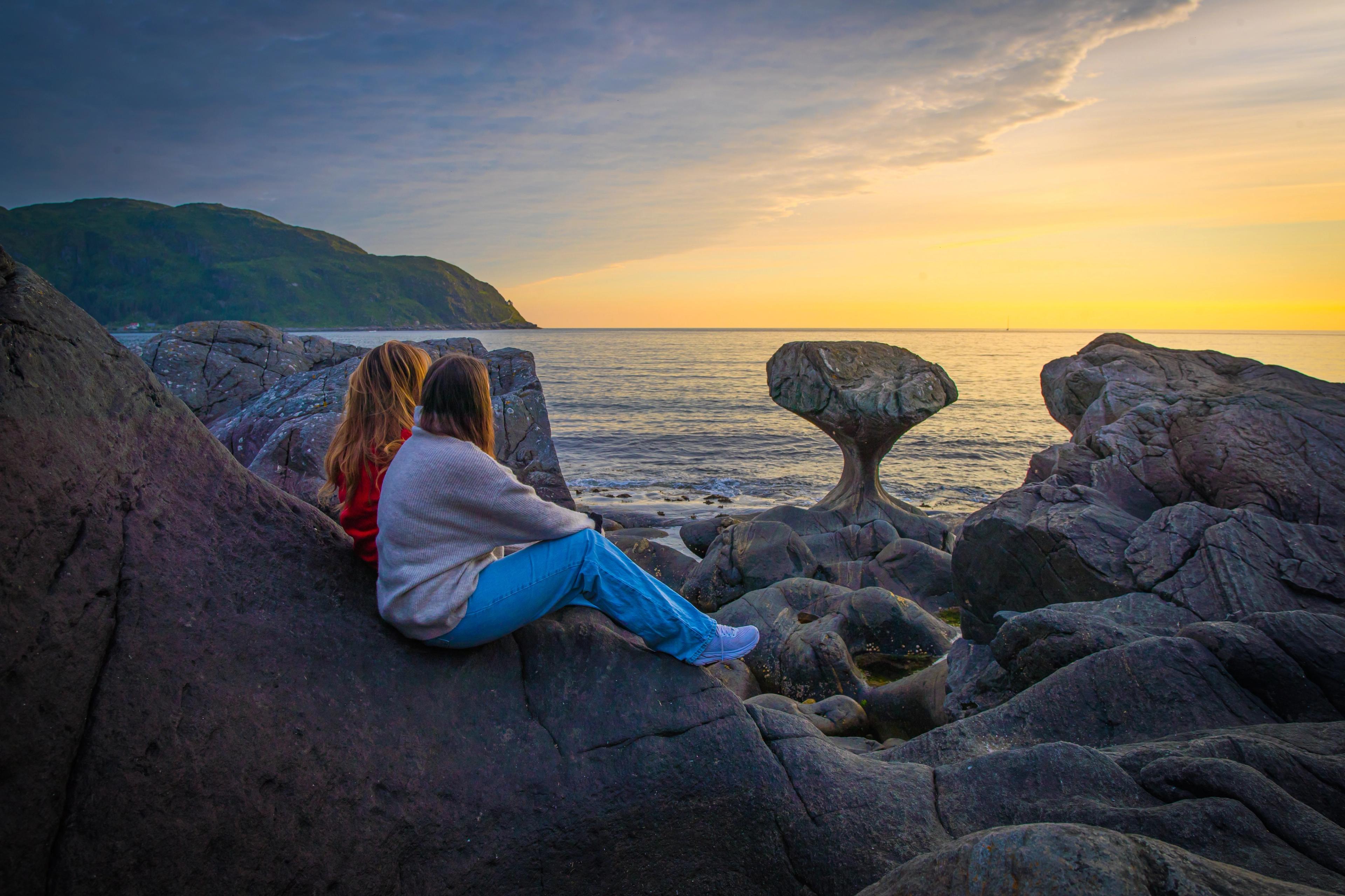 Two tourists by the Kannesteinen rock formation outside Måløy