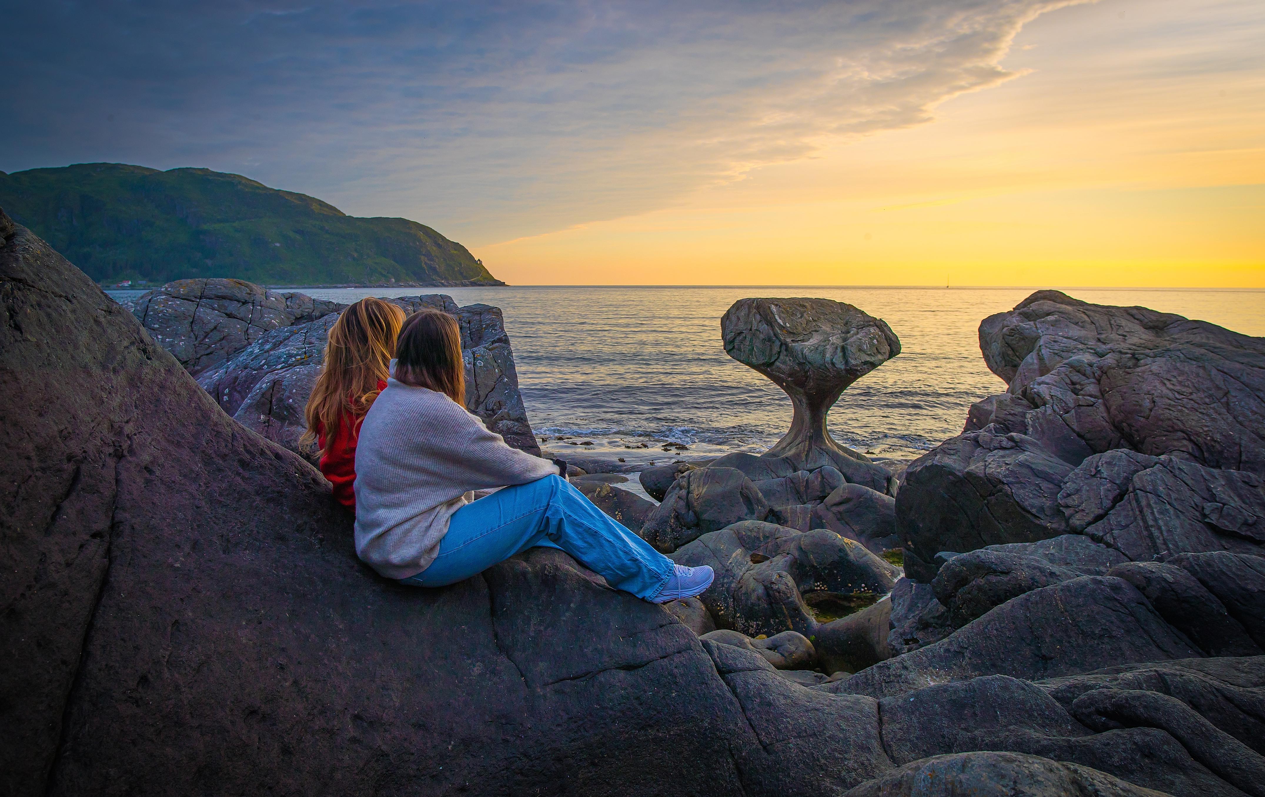 Two tourists by the Kannesteinen rock formation outside Måløy