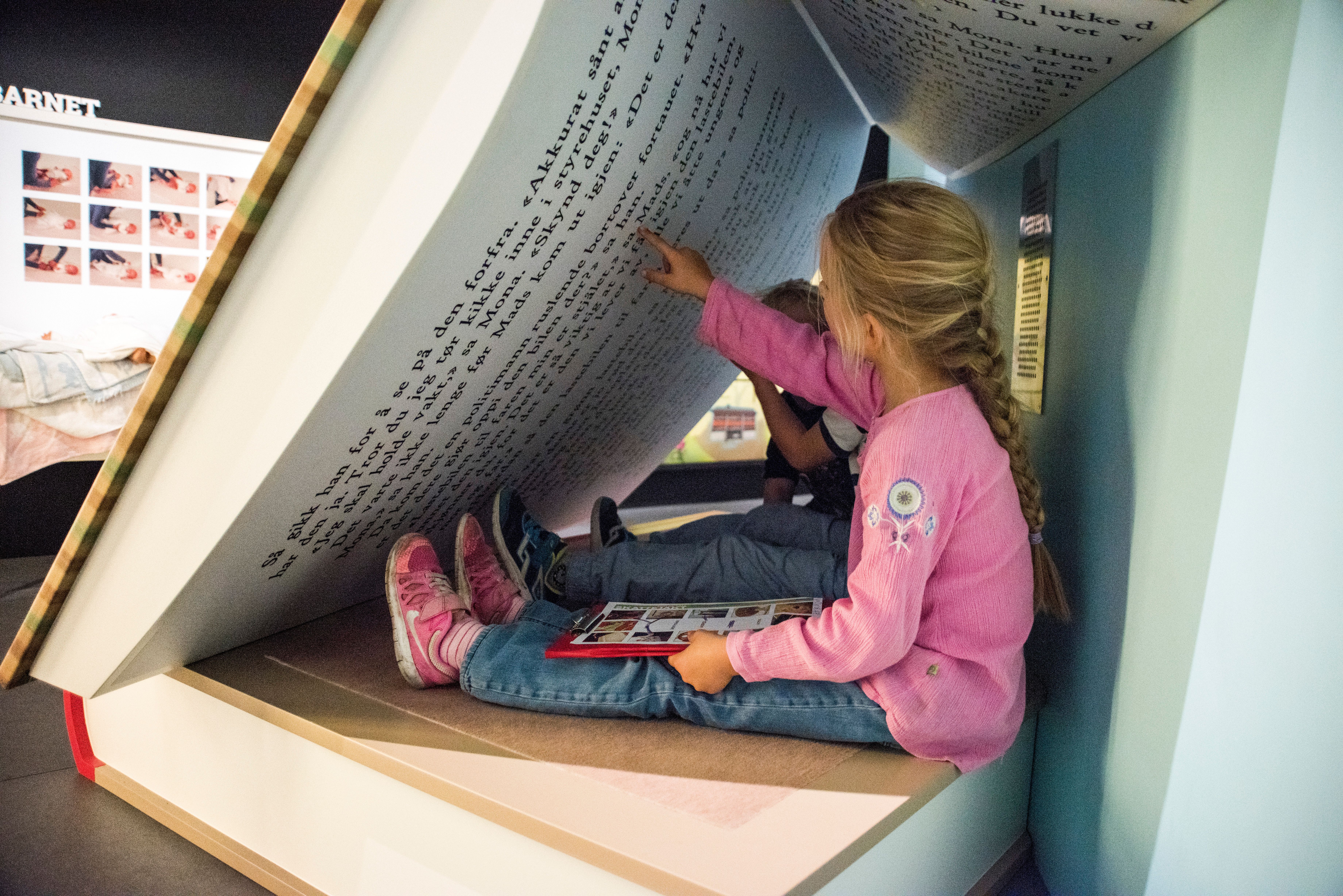 Children are seated in a giant book at Kuben Aust-Agder museum and archive in Arendal, Southern Norway.