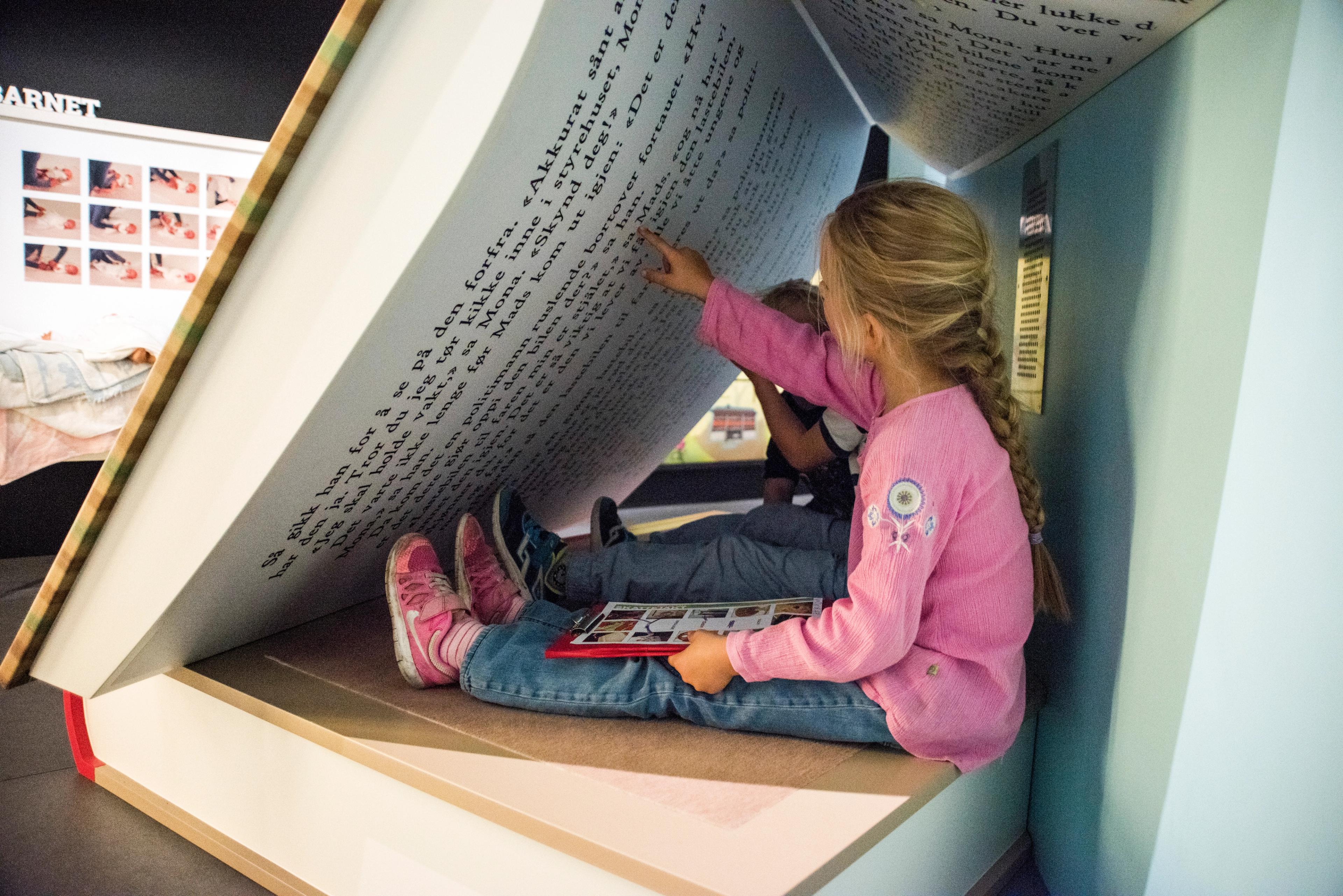 Children are seated in a giant book at Kuben Aust-Agder museum and archive in Arendal, Southern Norway.