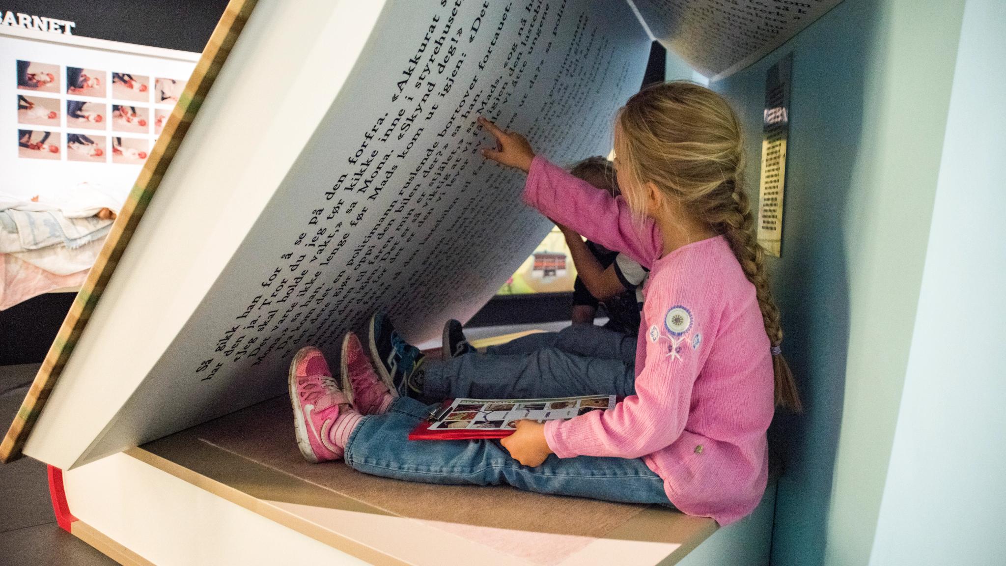 Children are seated in a giant book at Kuben Aust-Agder museum and archive in Arendal, Southern Norway.