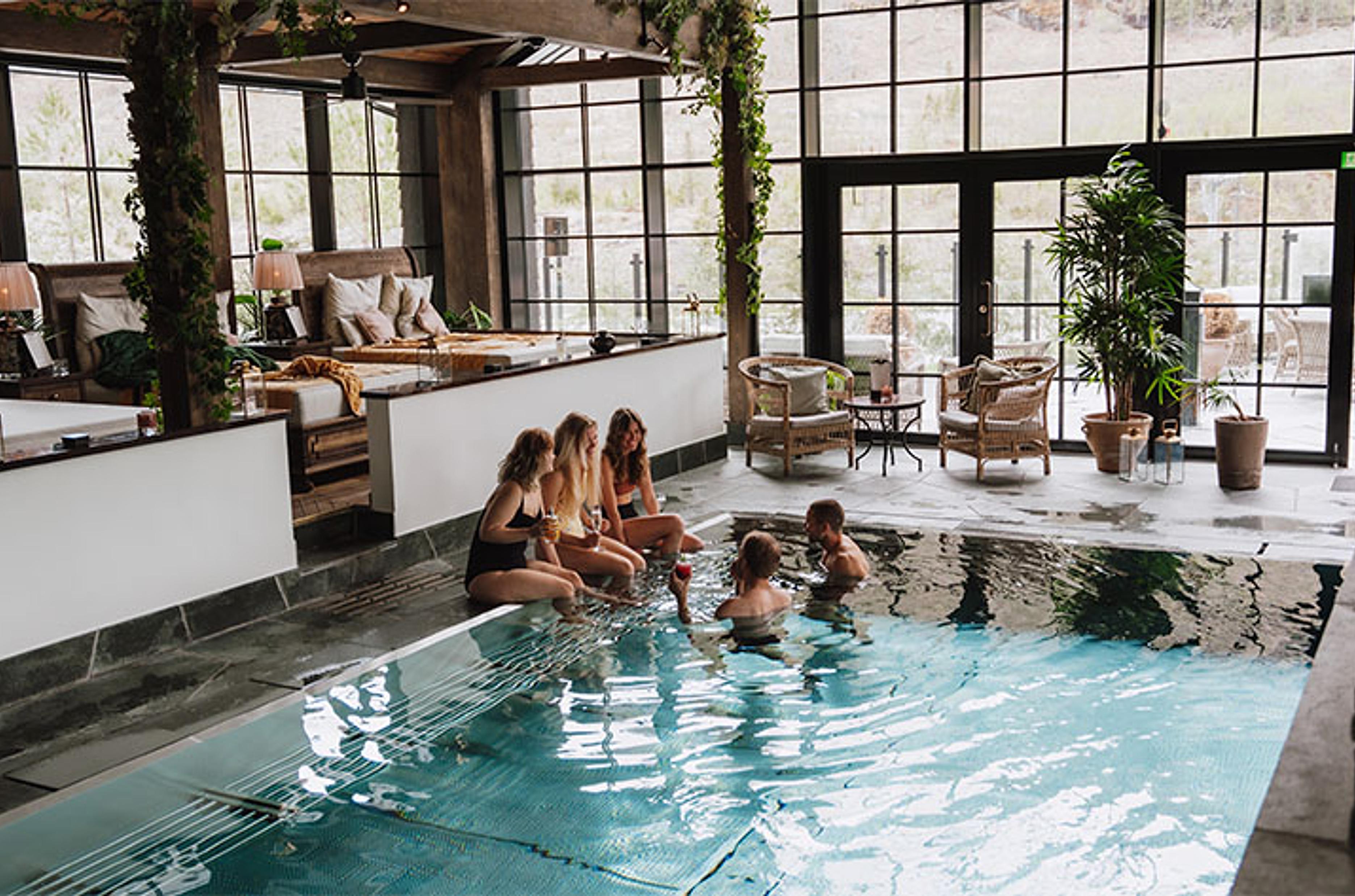 Friends enjoying the pool and spa area at Fyrí Resort, in Hemsedal