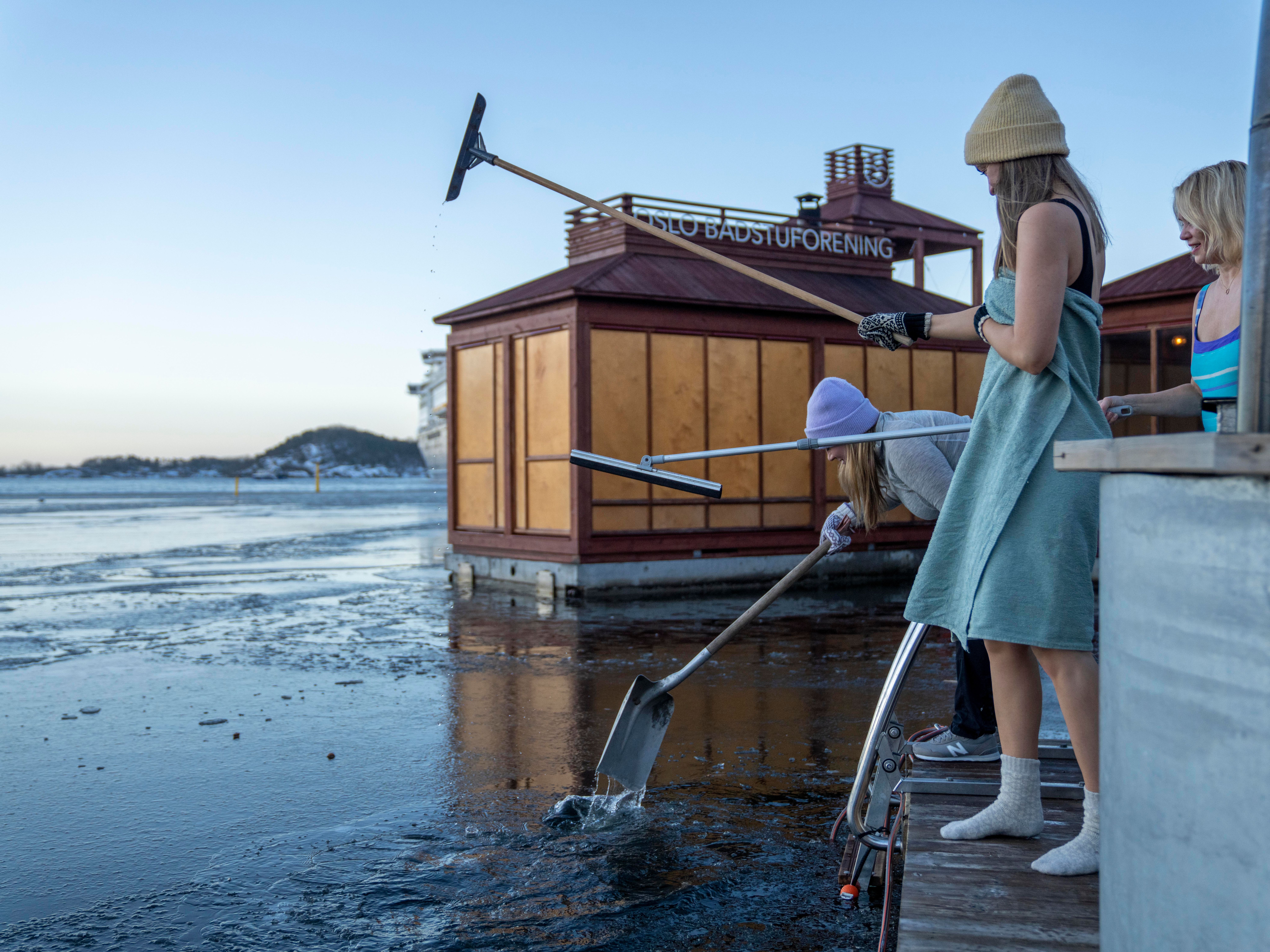 Friends crushing ice before ice bathing in the Oslofjord, Eastern Norway