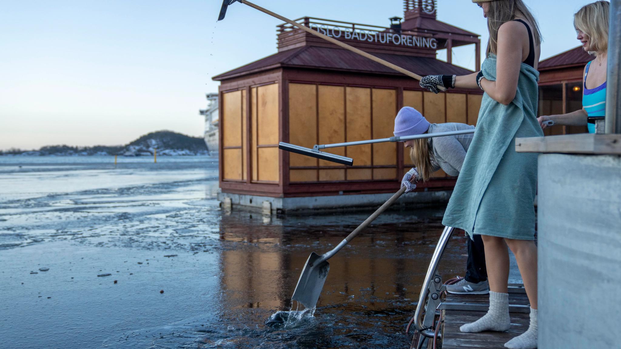Friends crushing ice before ice bathing in the Oslofjord, Eastern Norway