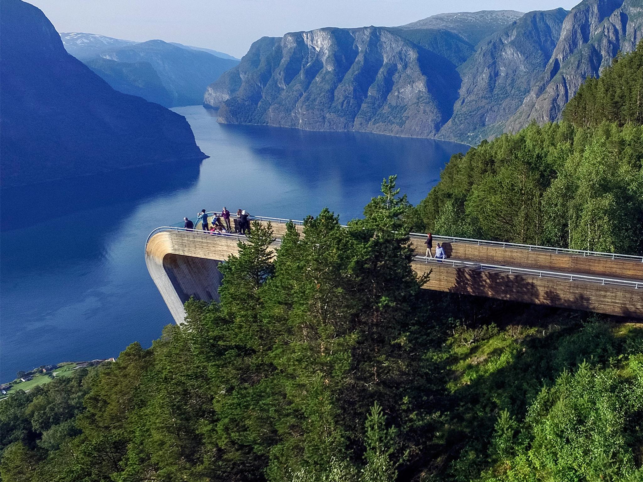 Menschen, die am Stegastein-Aussichtspunkt entlang der norwegischen Landschaftsroute Aurlandsfjellet stehen