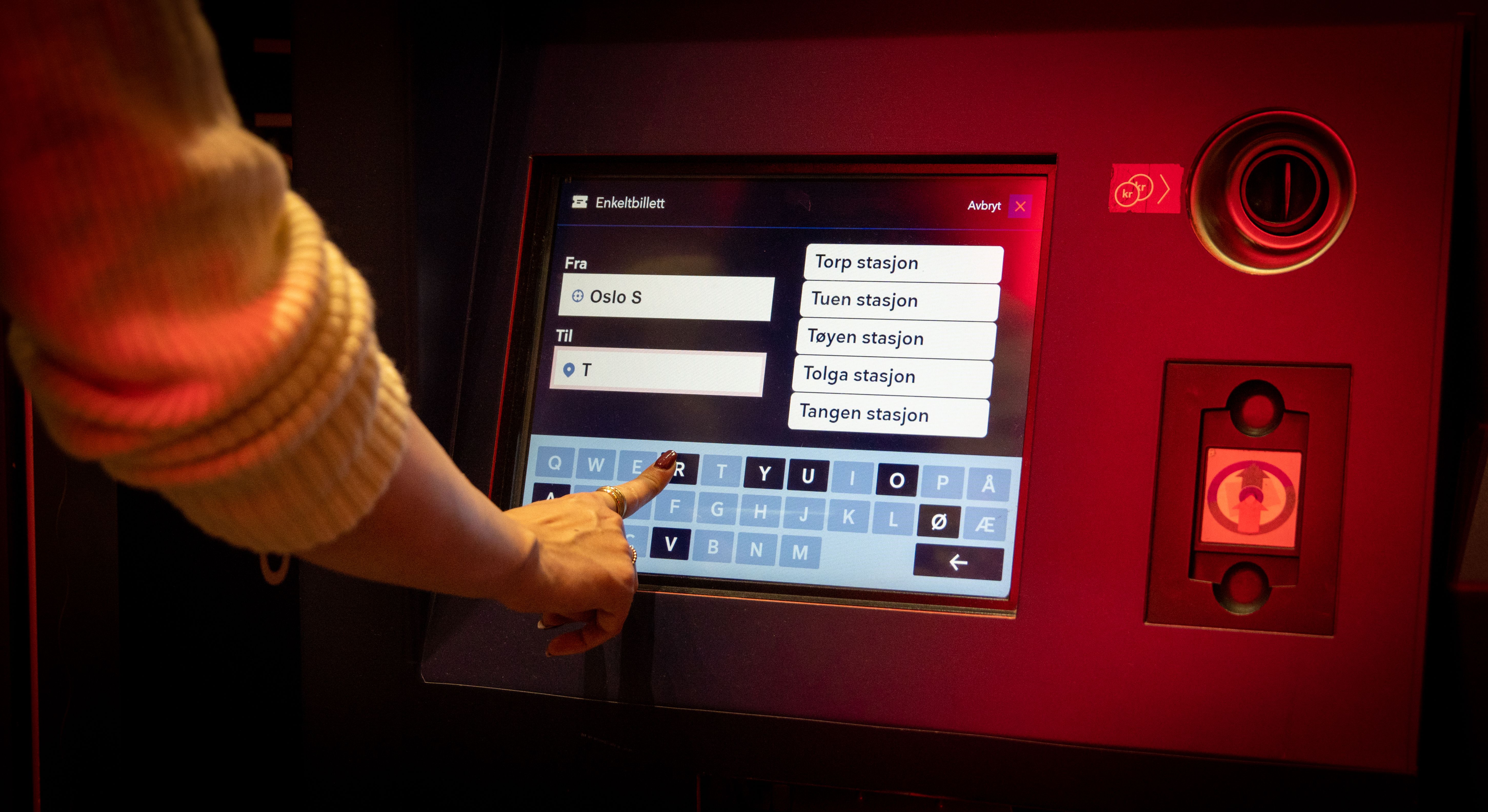 En kvinne kjøper togbilletter.