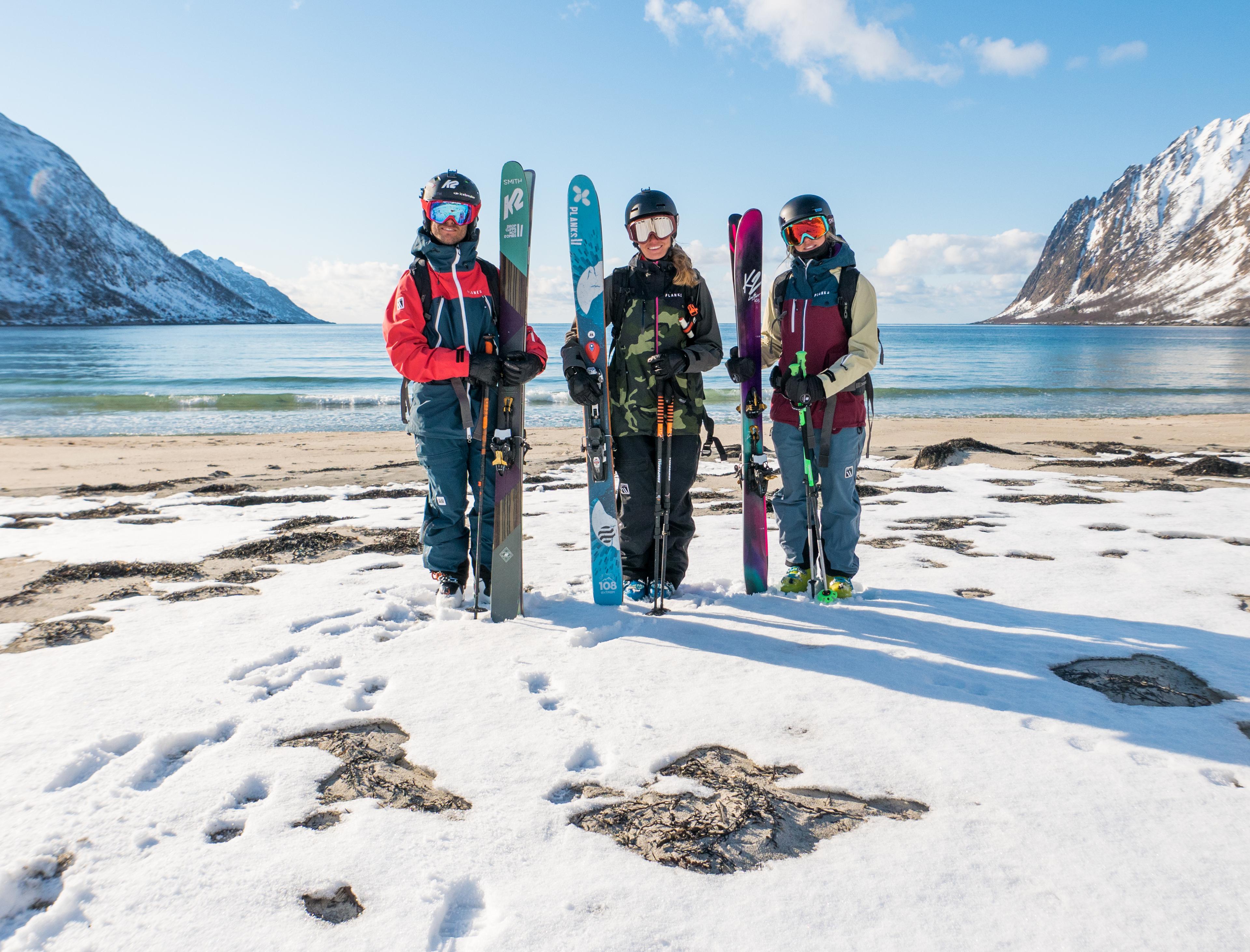 Three skiers just done mountain-to-beach-skiing in Senja