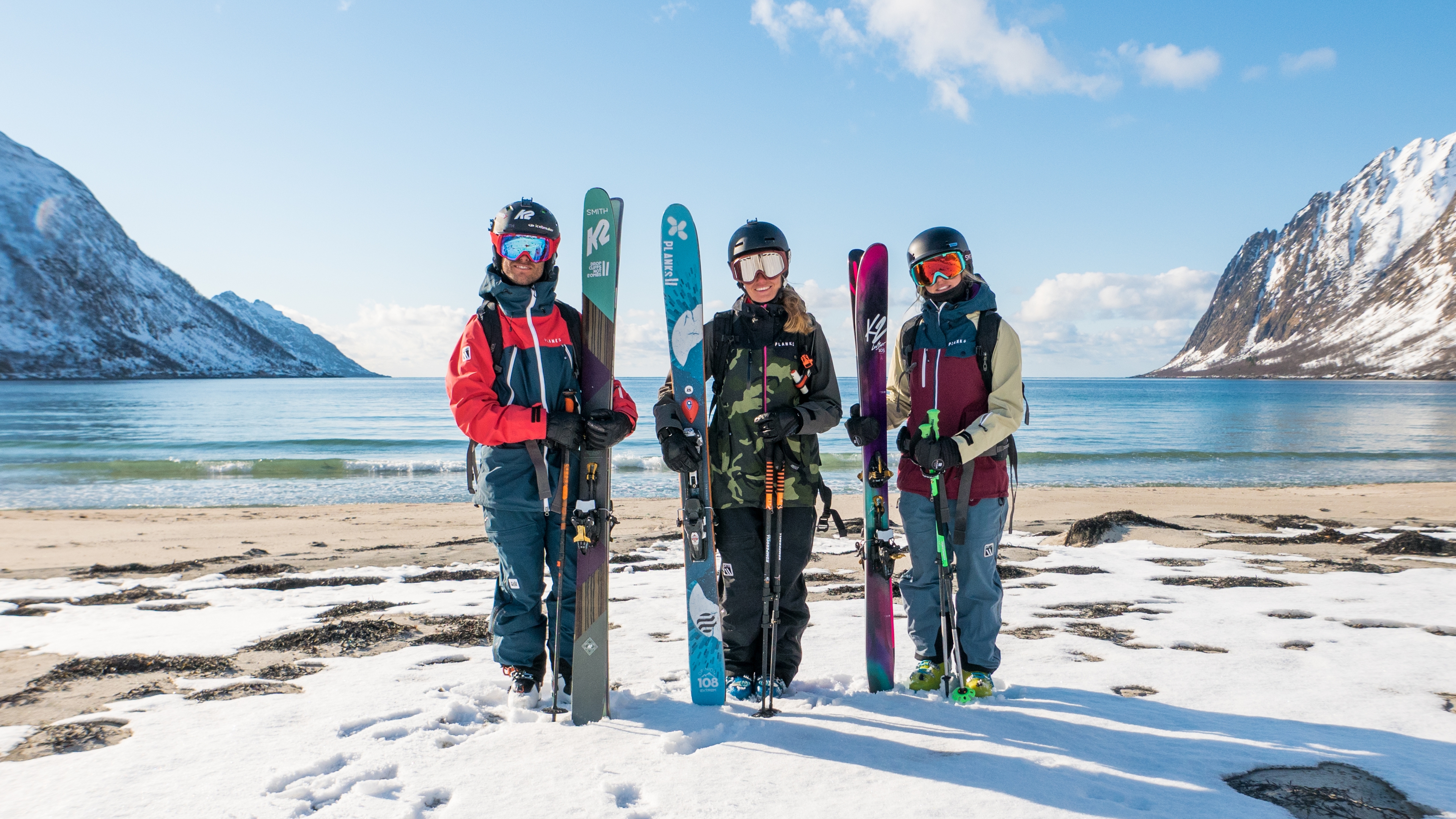 Three skiers just done mountain-to-beach-skiing in Senja