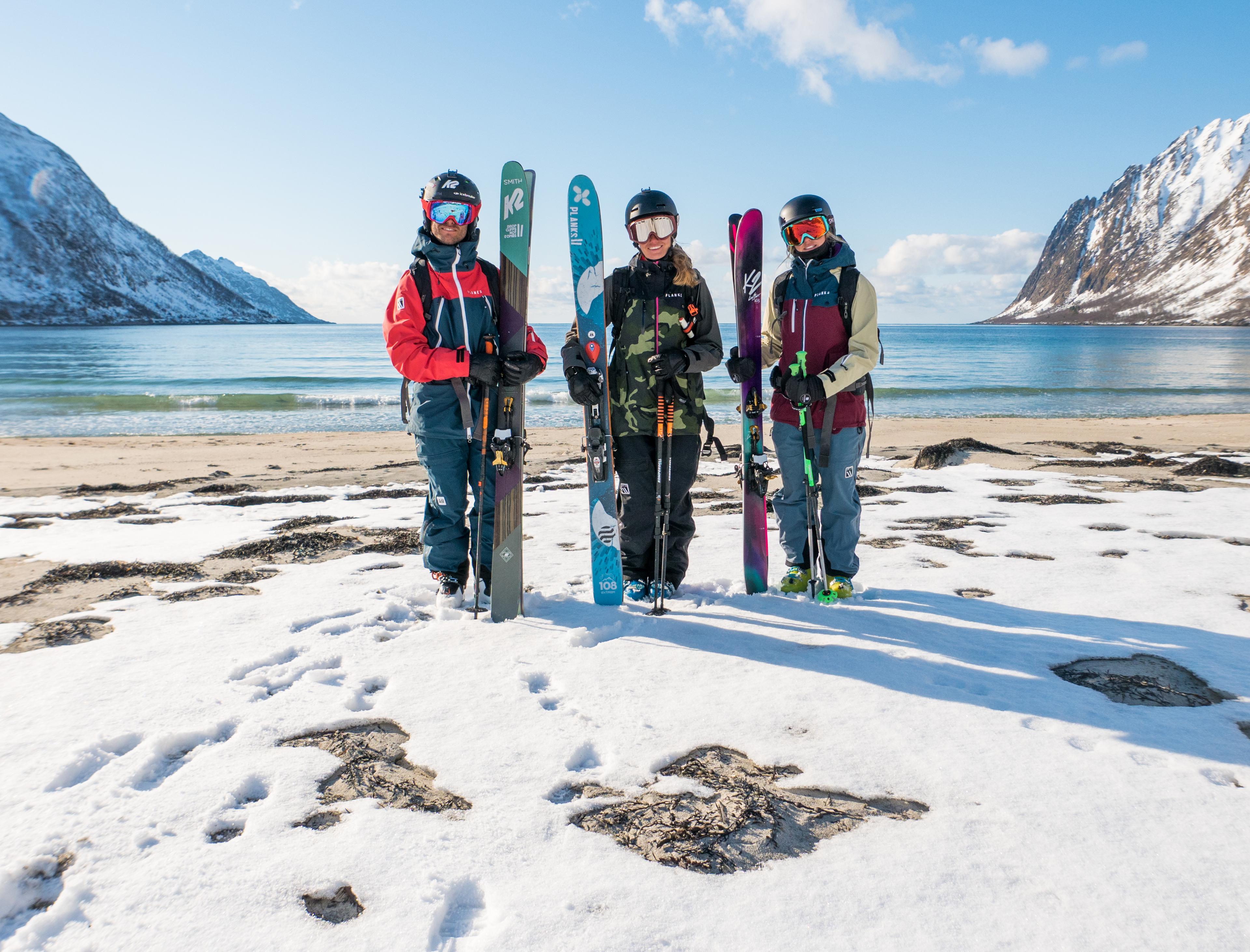 Three skiers just done mountain-to-beach-skiing in Senja
