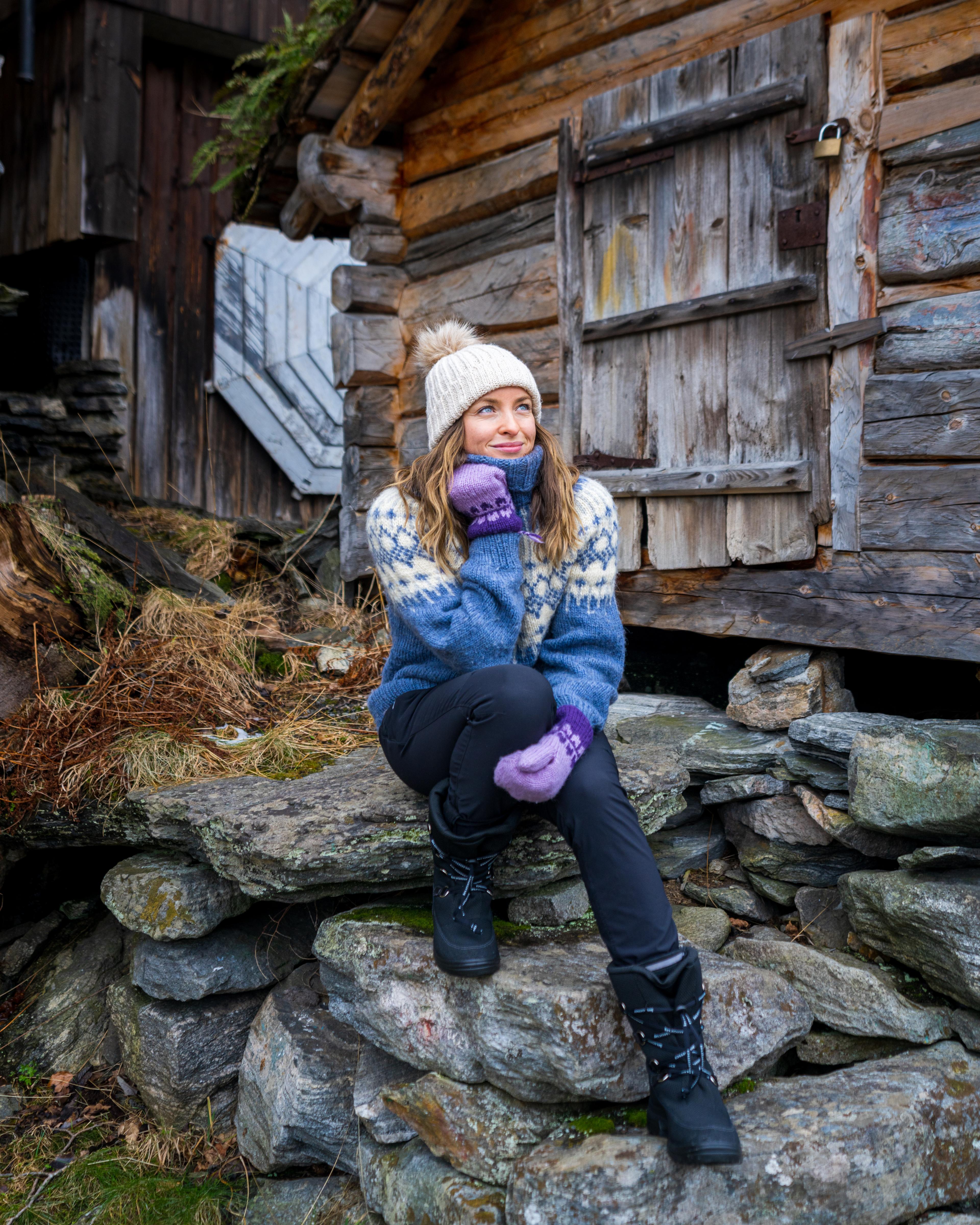 Woman sitting in some stone stairs by the harbor in Geiranger