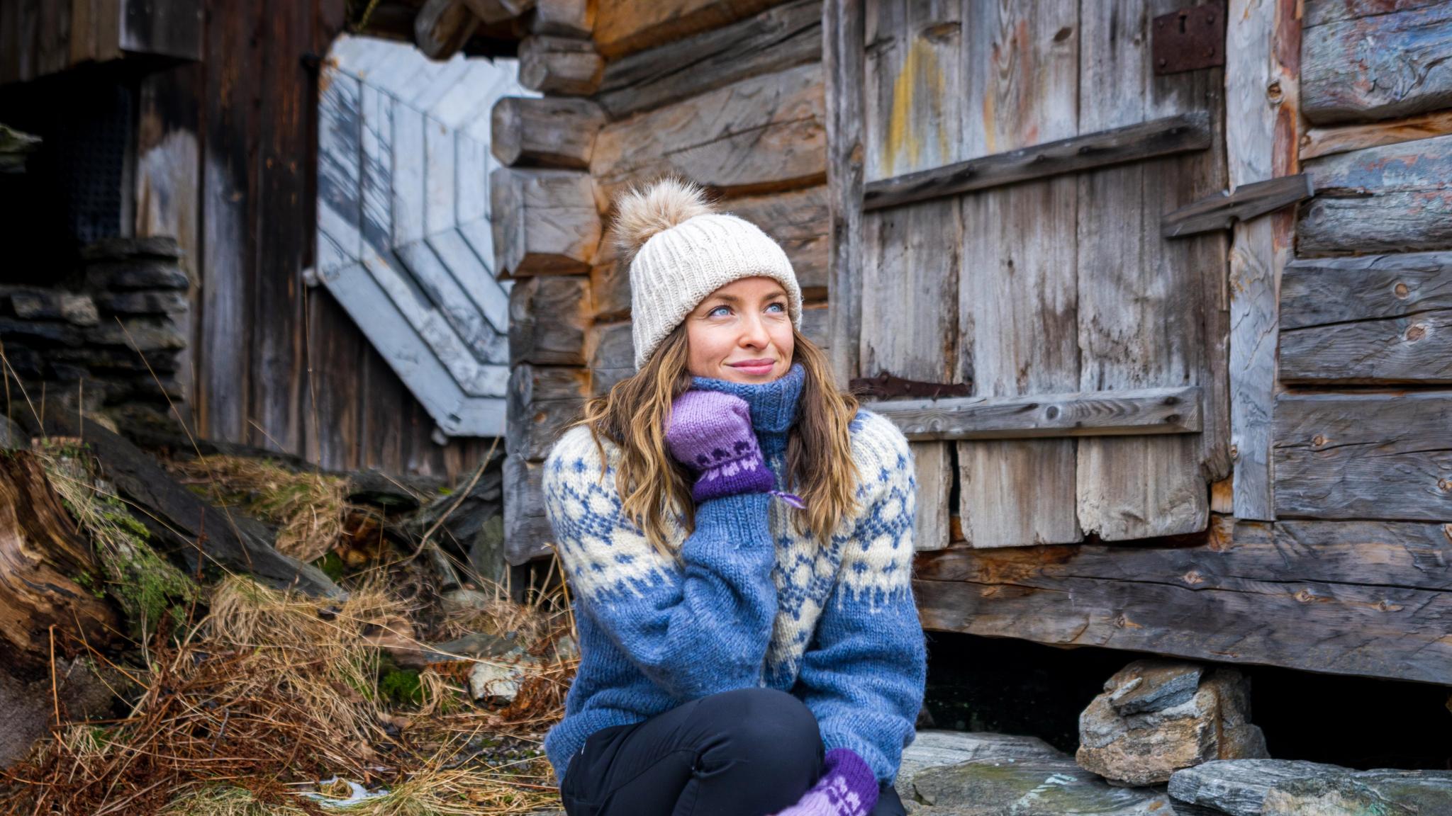 Woman sitting in some stone stairs by the harbor in Geiranger