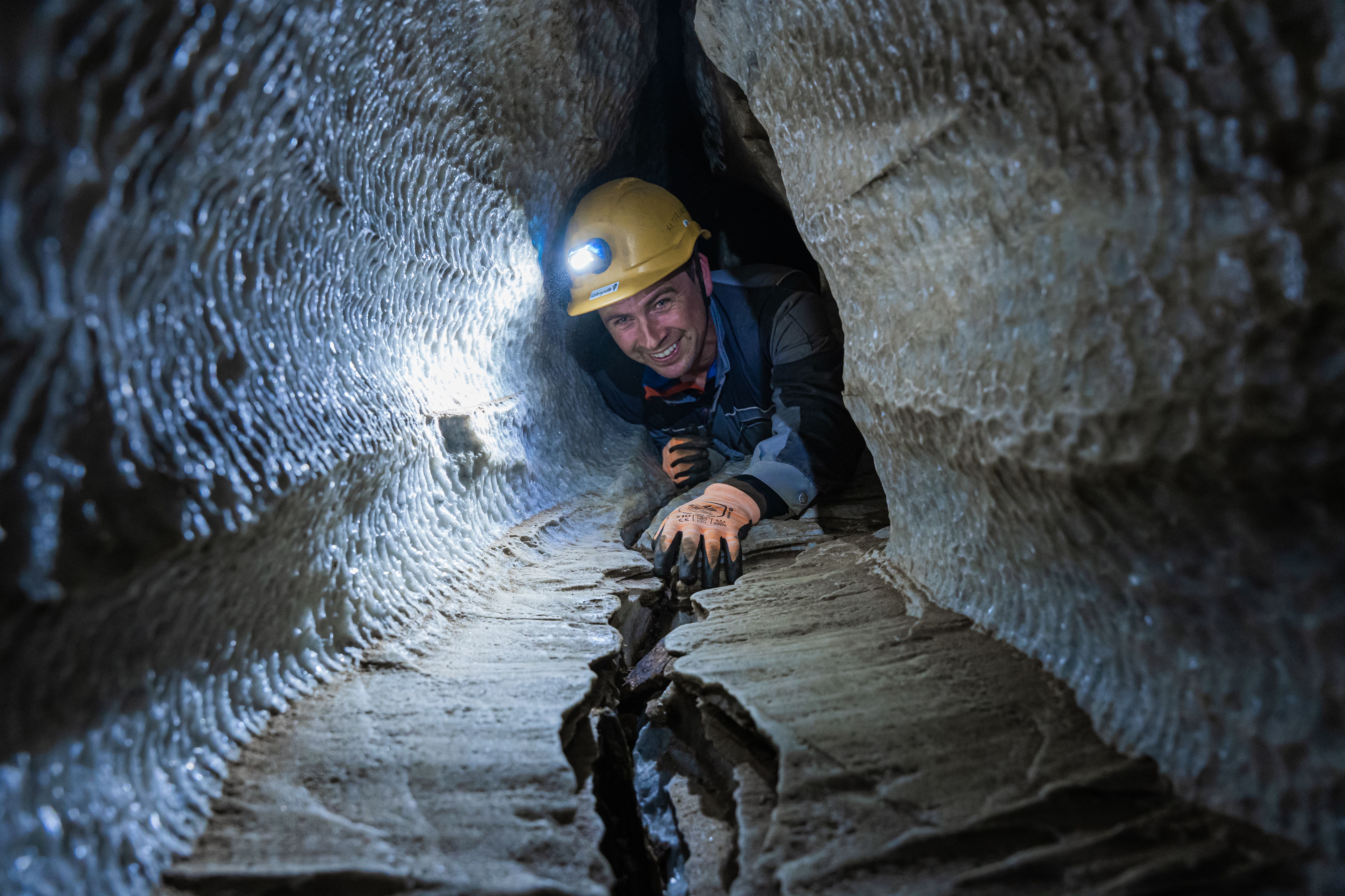 Person with a helmet on a guided tour in Setergrotta in Mo i Rana, Northern Norway