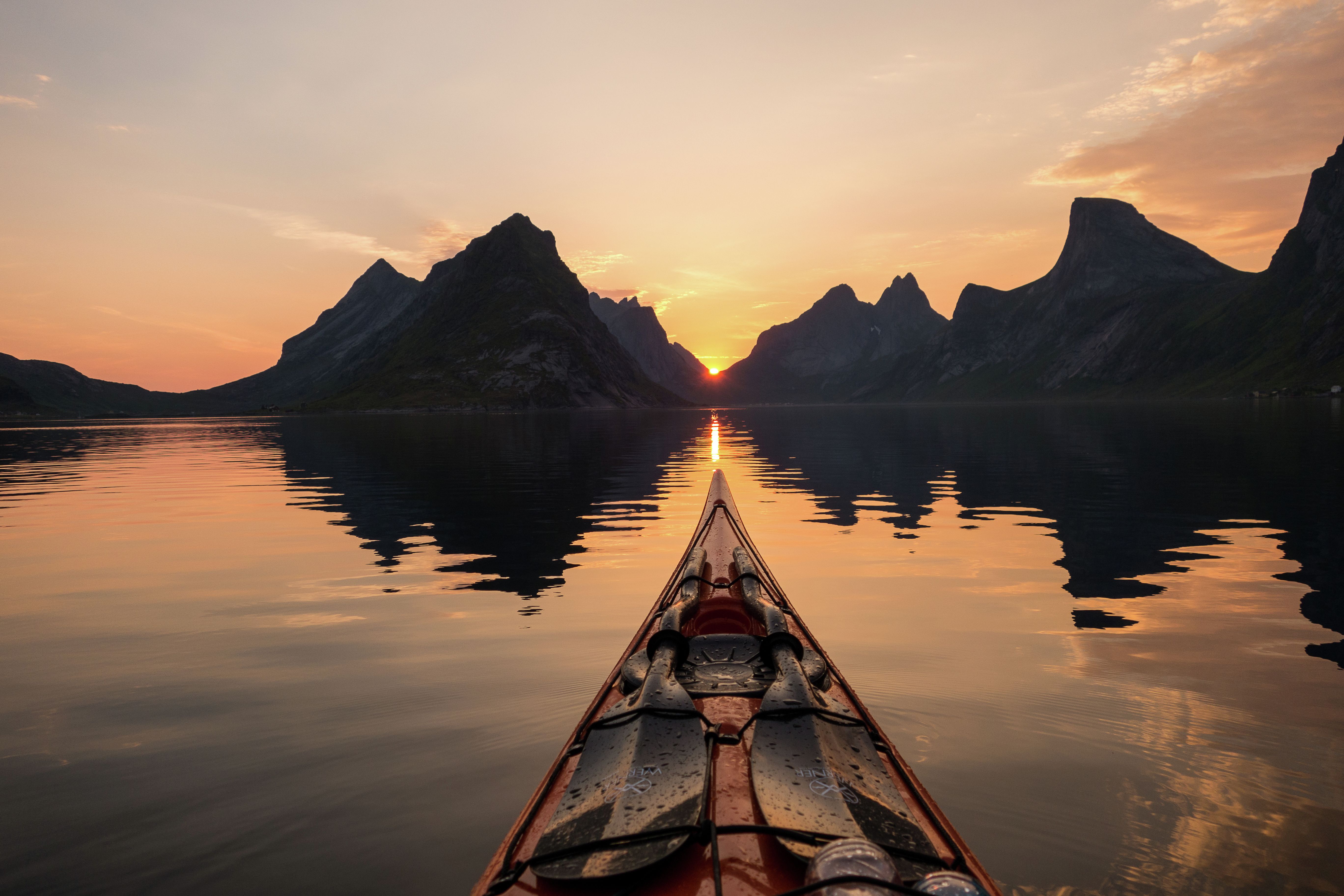 Kayaking under the midnight sun in Reinefjorden in Lofoten, Northern Norway