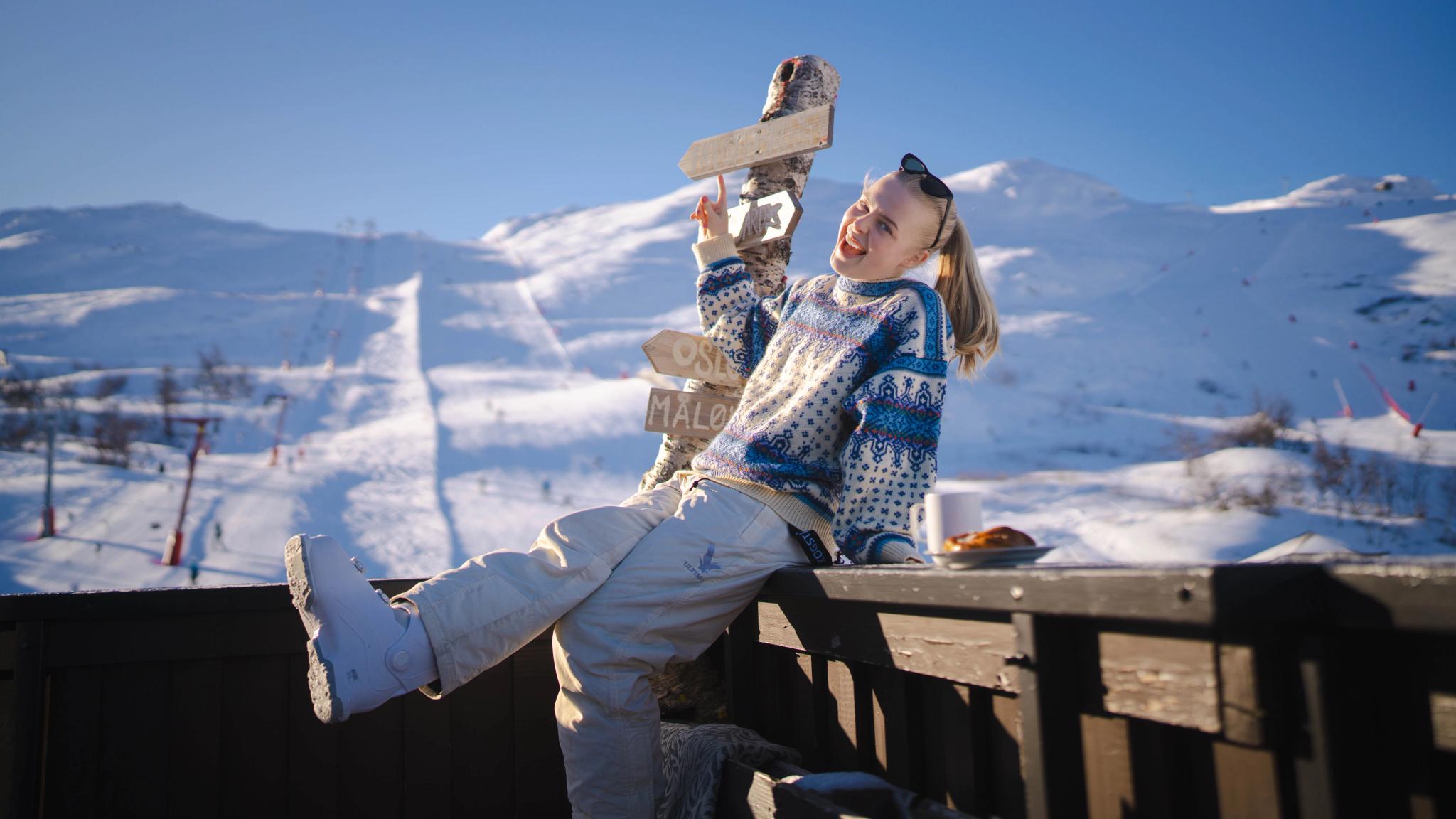 A girl basking in the sun outside Fjellkafeen café on the slopes of Hemsedal
