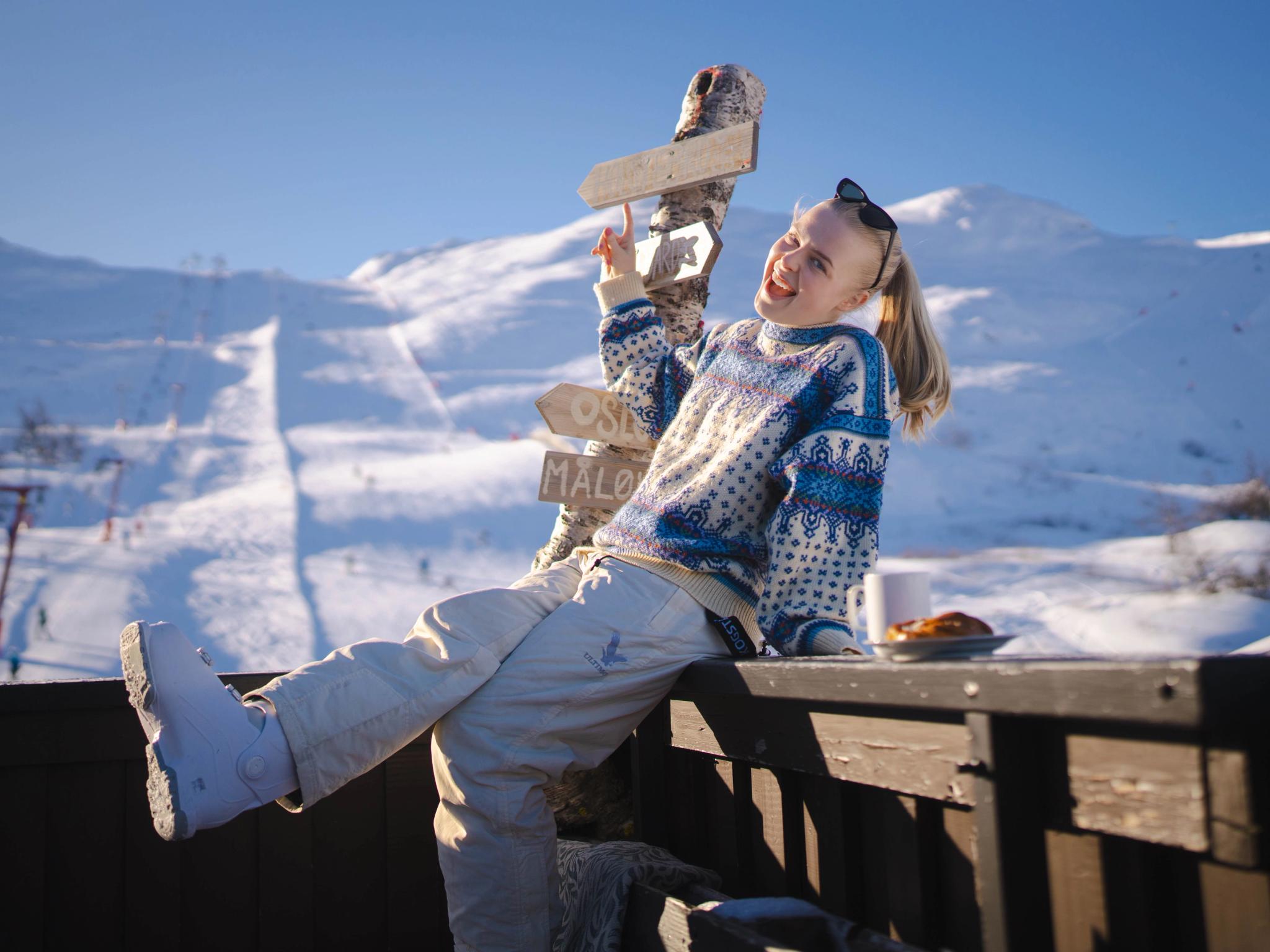 A girl basking in the sun outside Fjellkafeen café on the slopes of Hemsedal