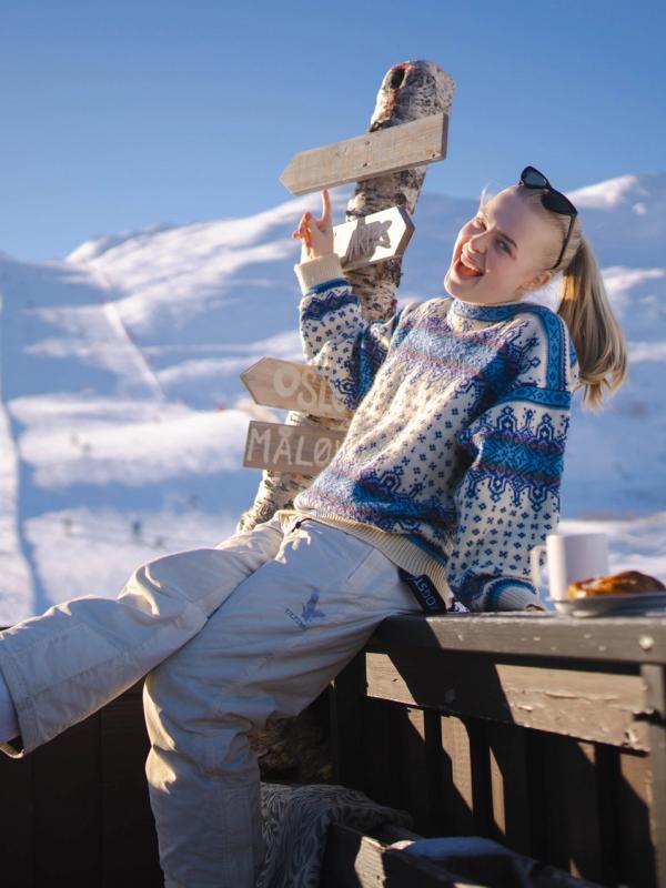 A girl basking in the sun outside Fjellkafeen café on the slopes of Hemsedal