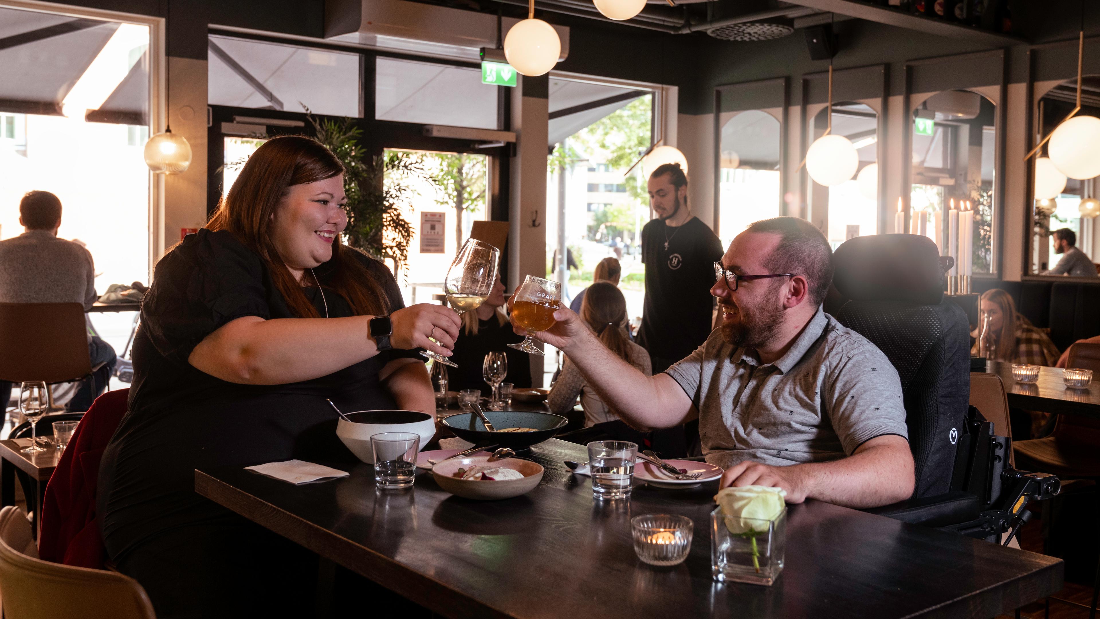 A woman and a man toasting on a restaurant in Tromsø, Northern Norway
