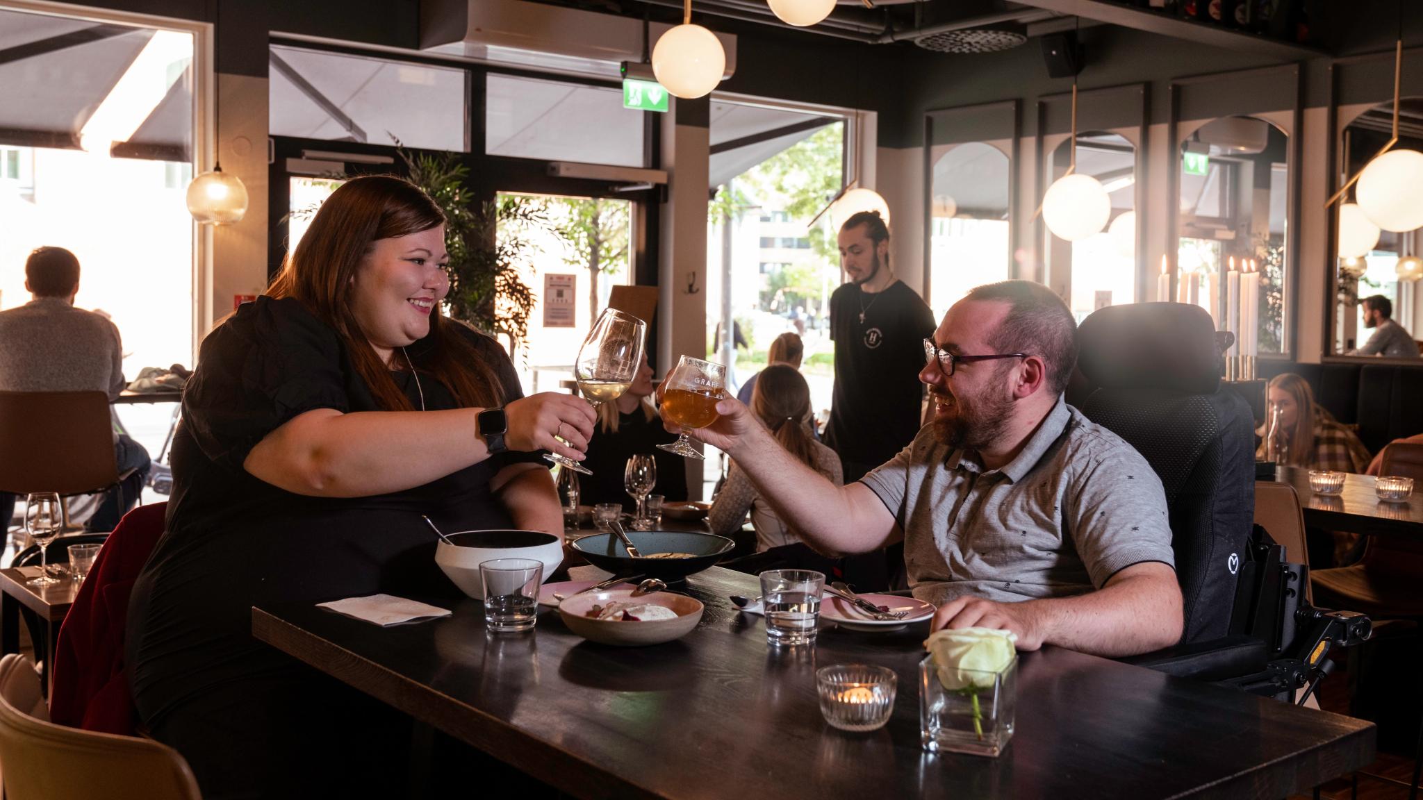 A woman and a man toasting on a restaurant in Tromsø, Northern Norway
