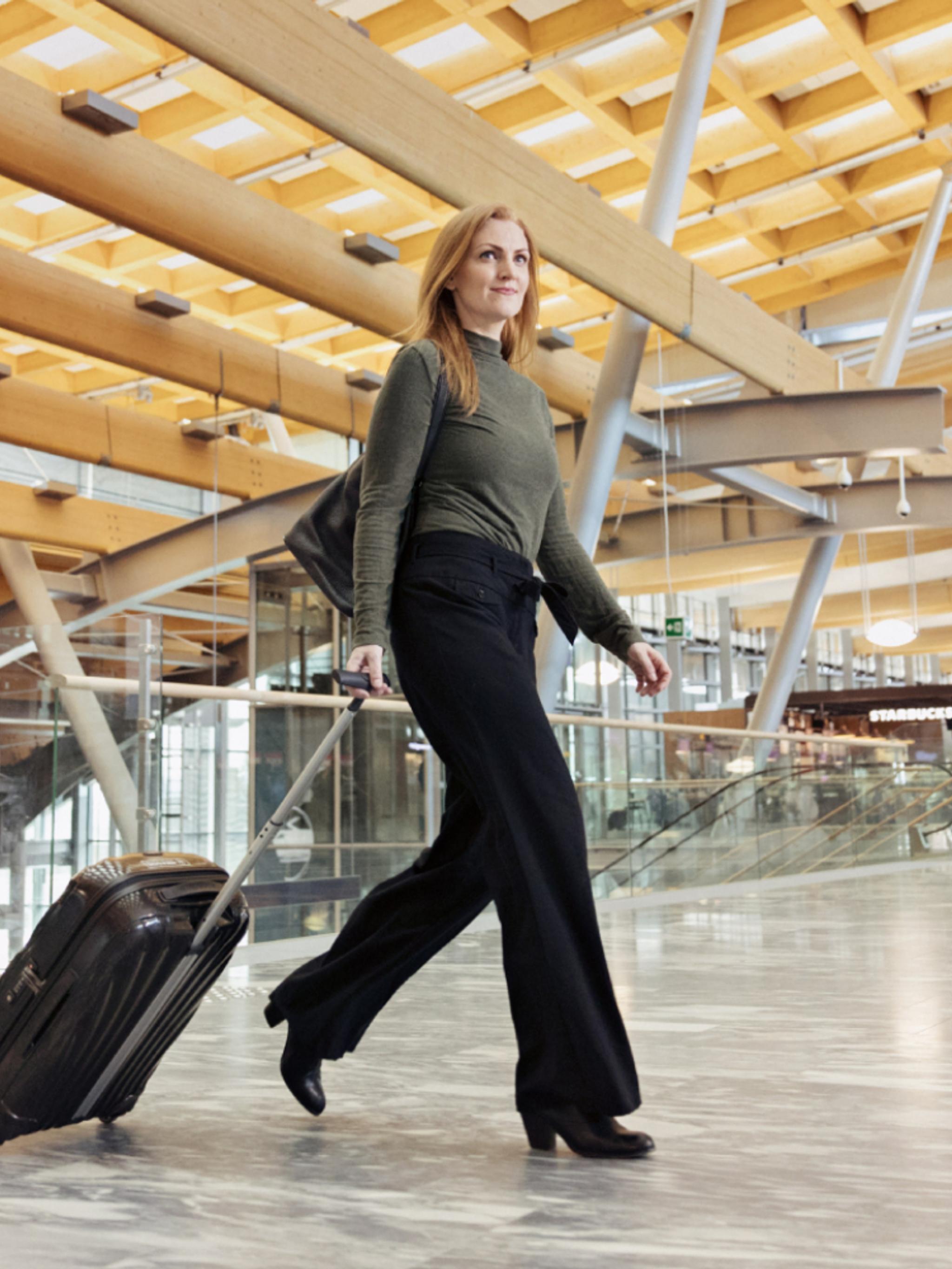 Woman with suitcase at Oslo Airport Gardermoen