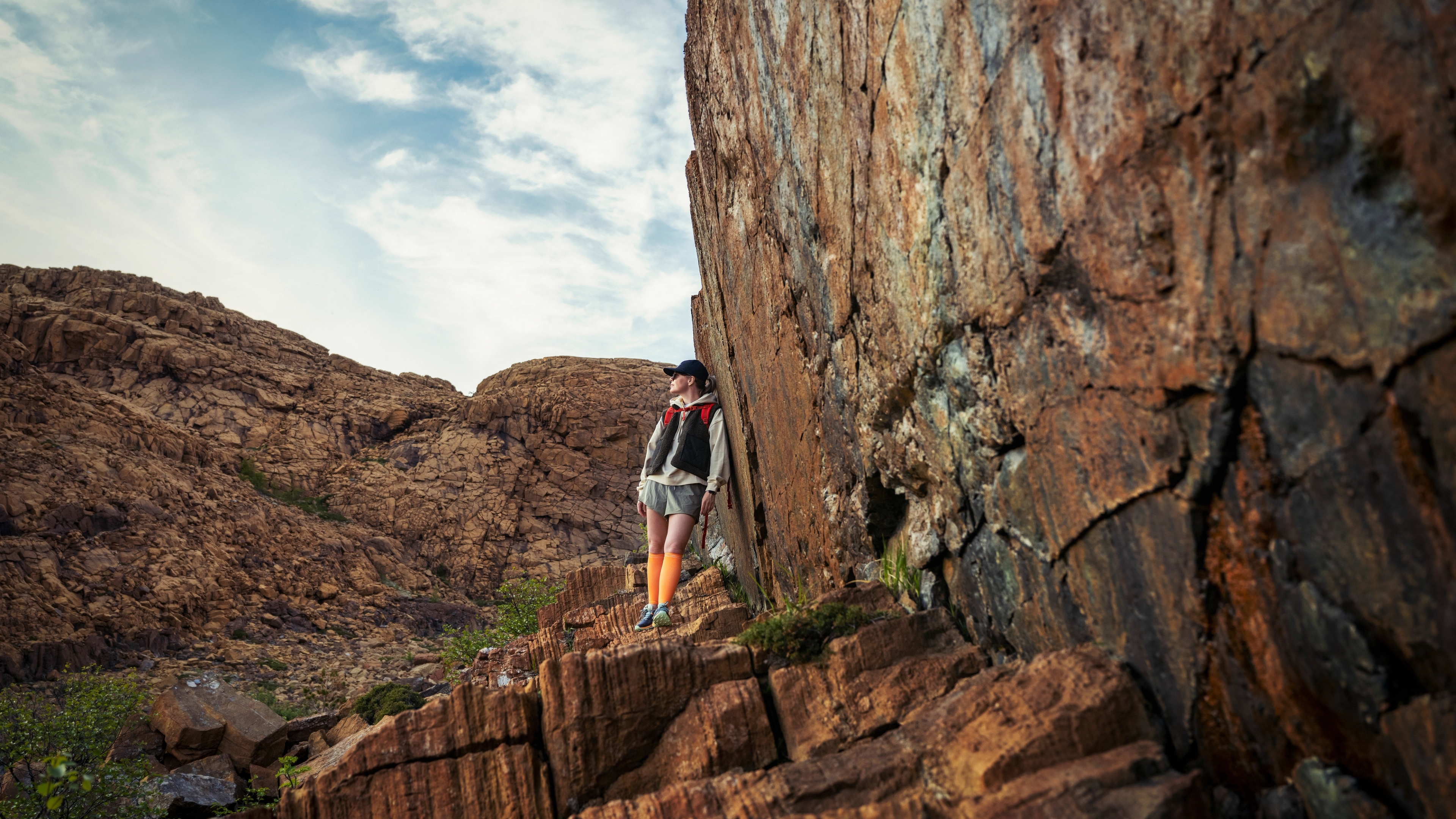 Woman hiking between the red rocks at Leka island in Trøndelag