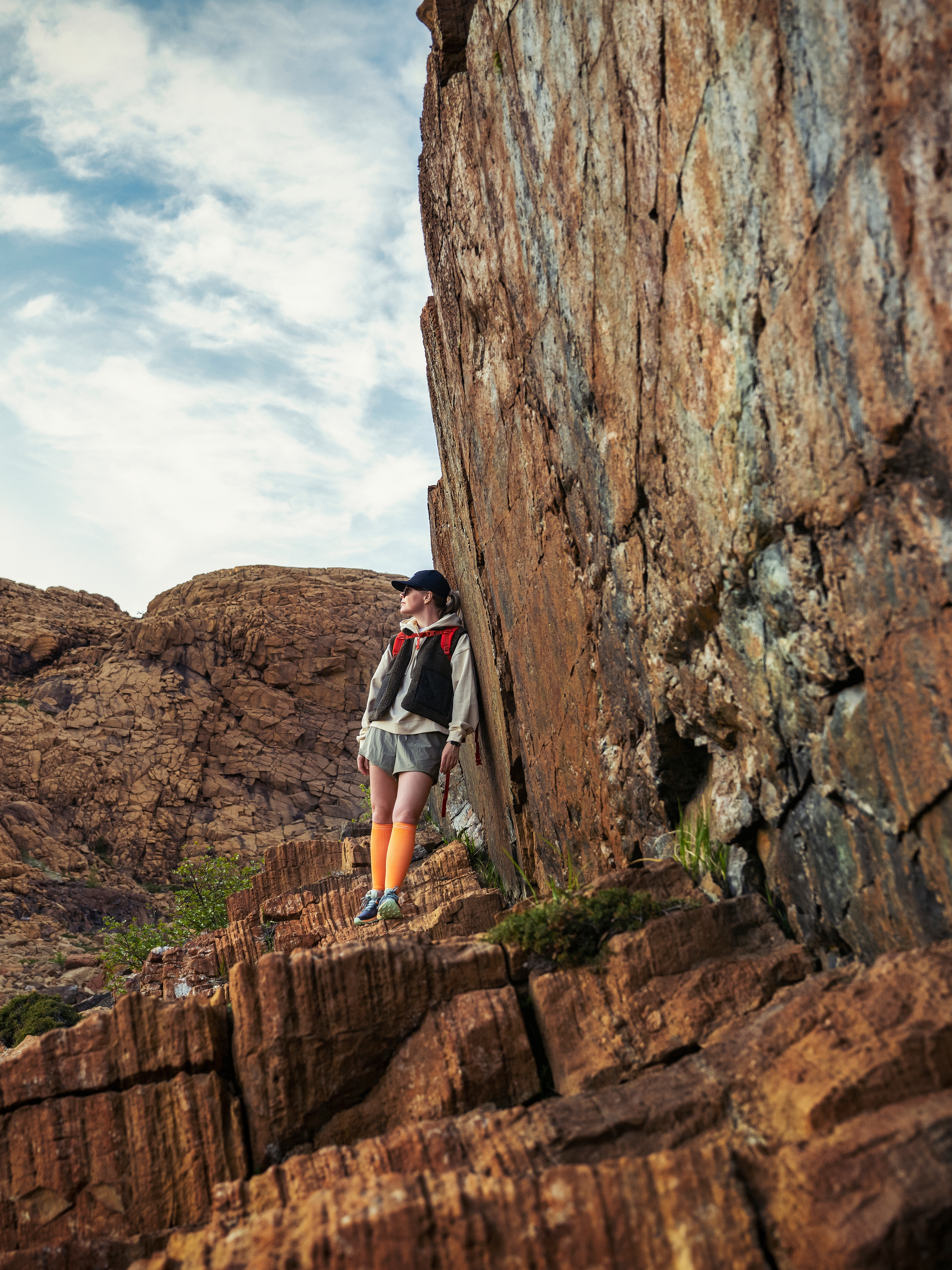 Woman hiking between the red rocks at Leka island in Trøndelag