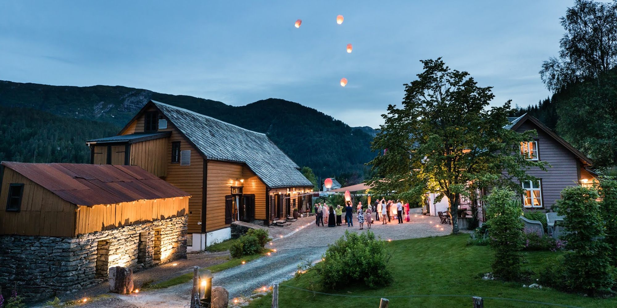 A group of people outside of Villa Åmot letting go of a few wishing lanterns, Sunnfjord, Fjord Norway