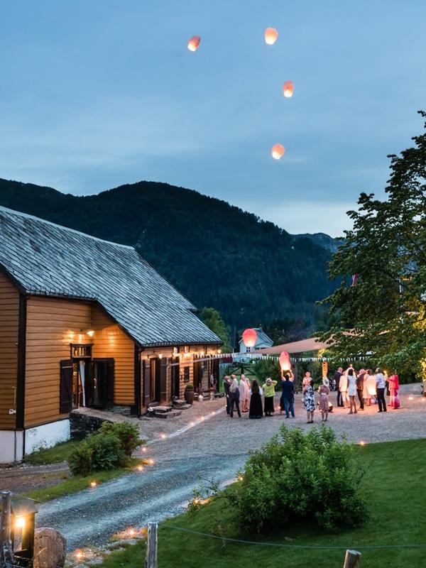 A group of people outside of Villa Åmot letting go of a few wishing lanterns, Sunnfjord, Fjord Norway