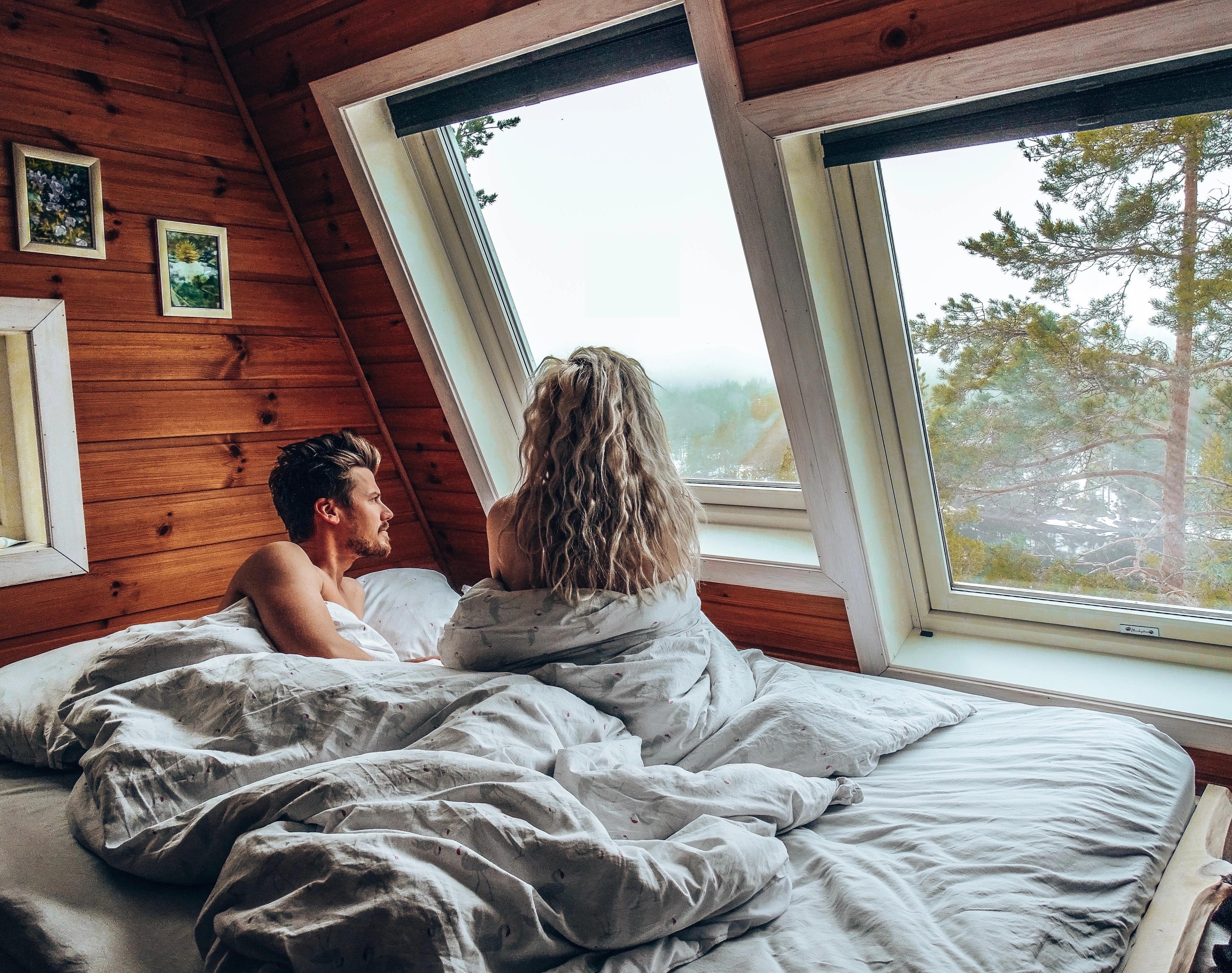 A man and a woman in bed inside on of the Micro cabins in Kragerø in Telemark, Eastern Norway