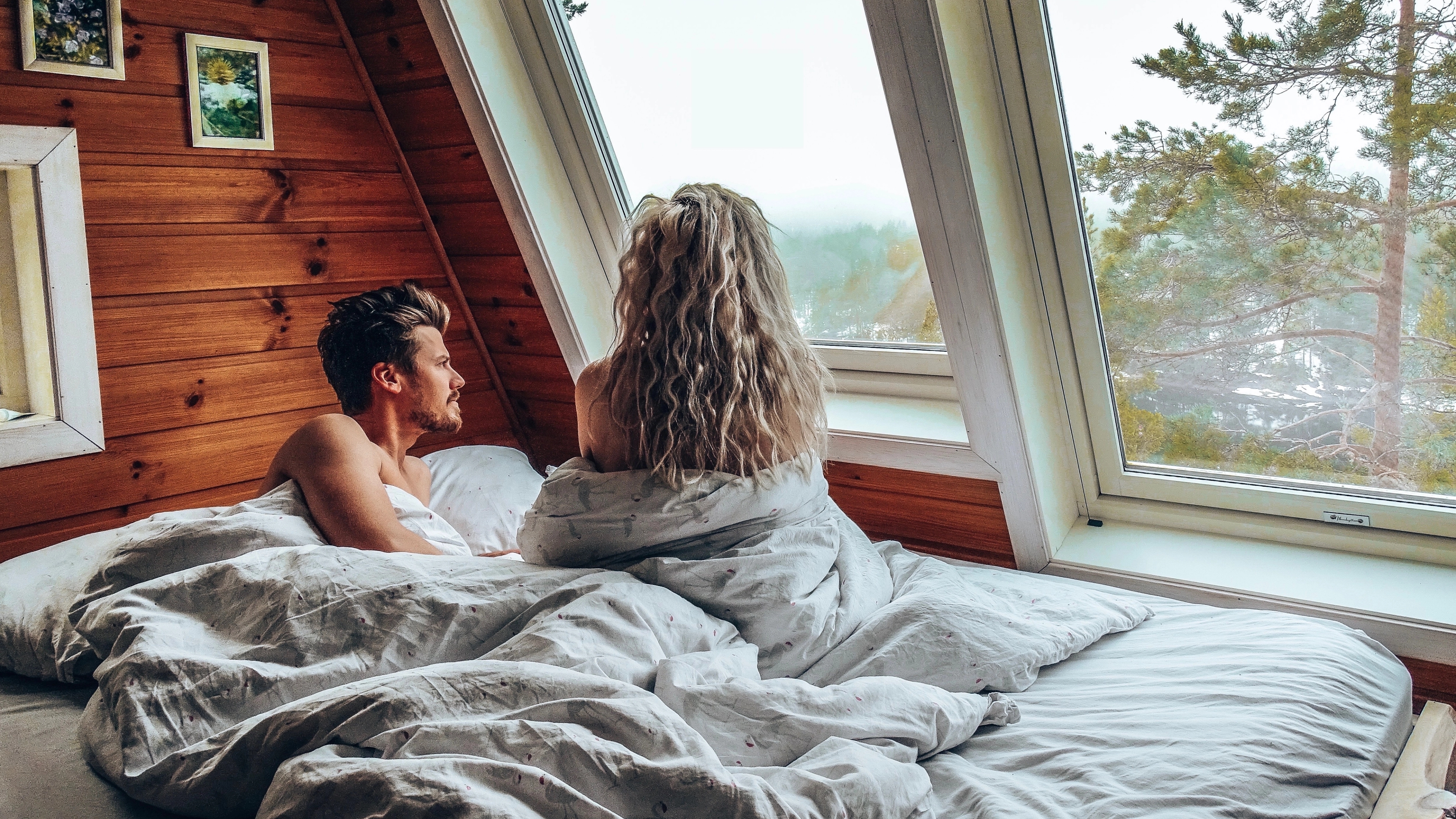 A man and a woman in bed inside on of the Micro cabins in Kragerø in Telemark, Eastern Norway