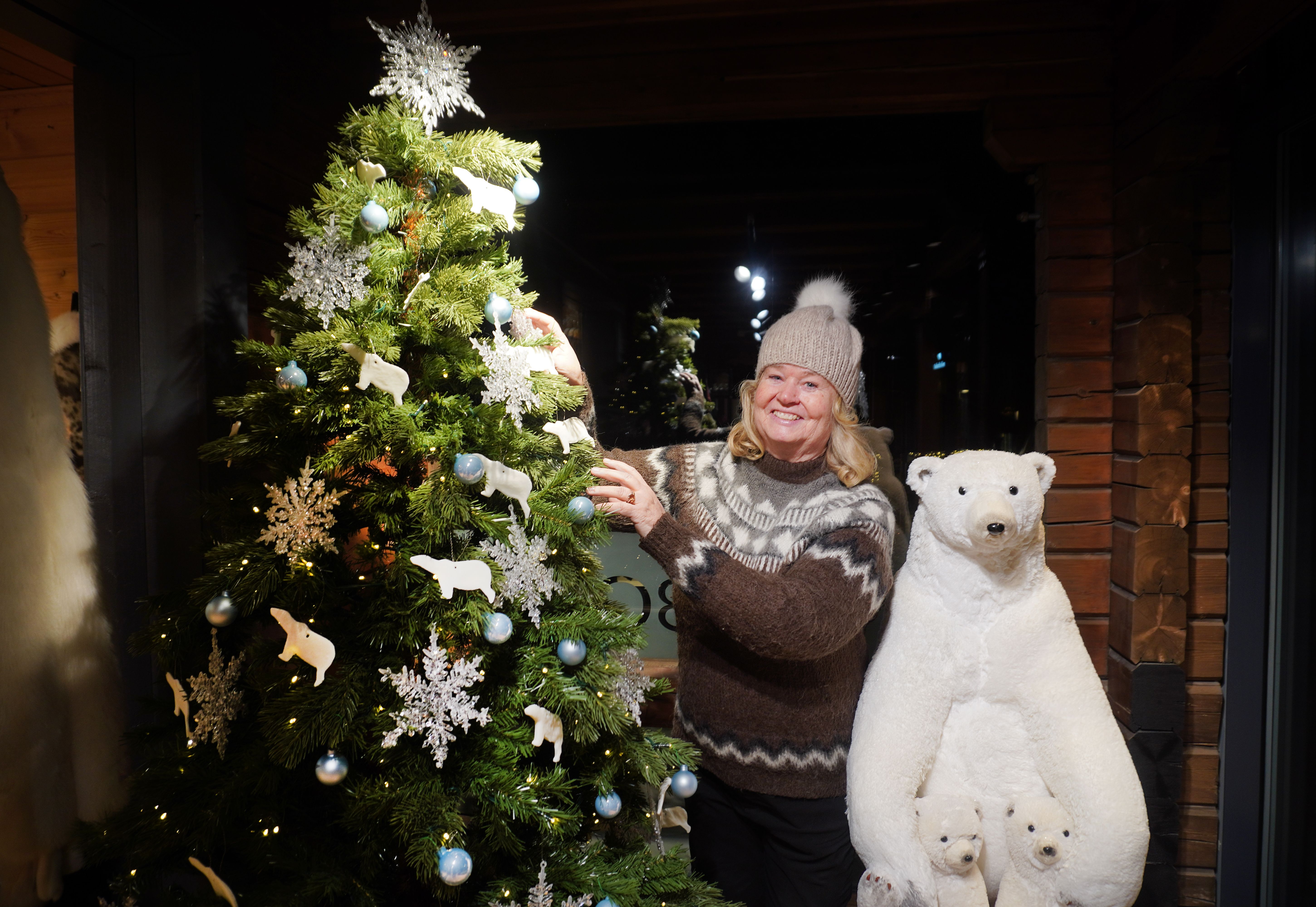 A woman beside polar bear teddy bears and a Christmas tree