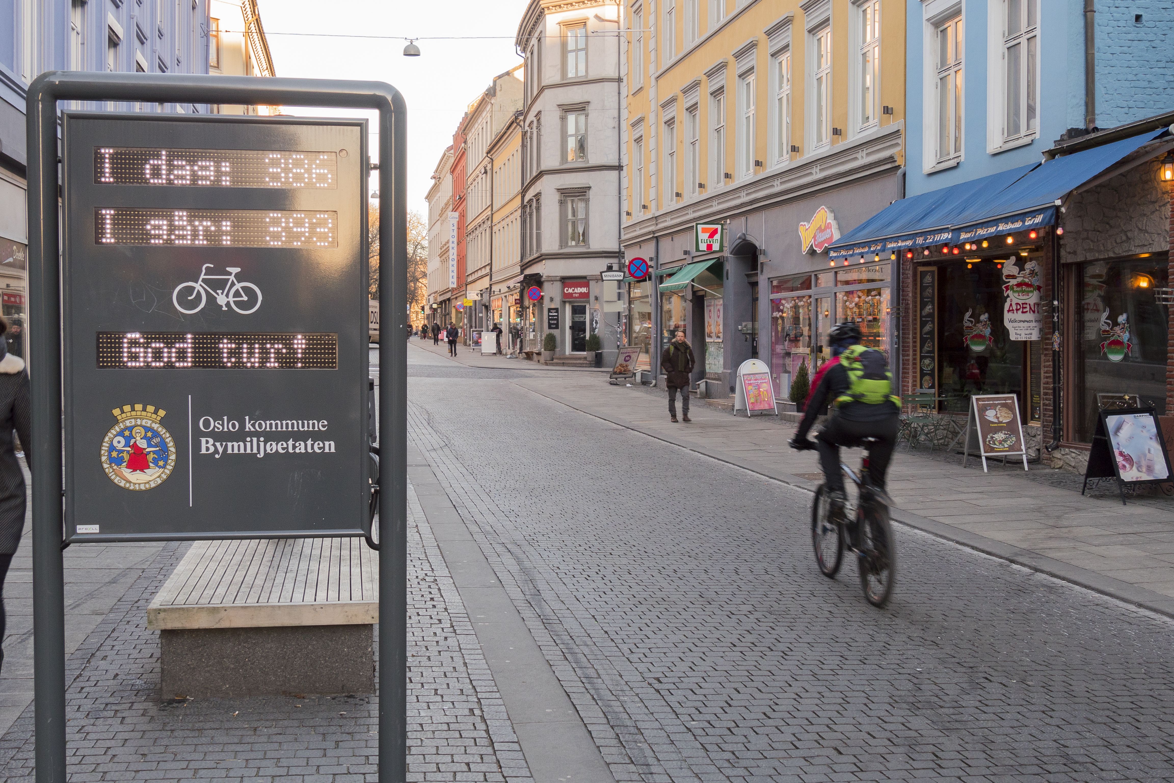 A person cycling past a sign that registers passing bikes