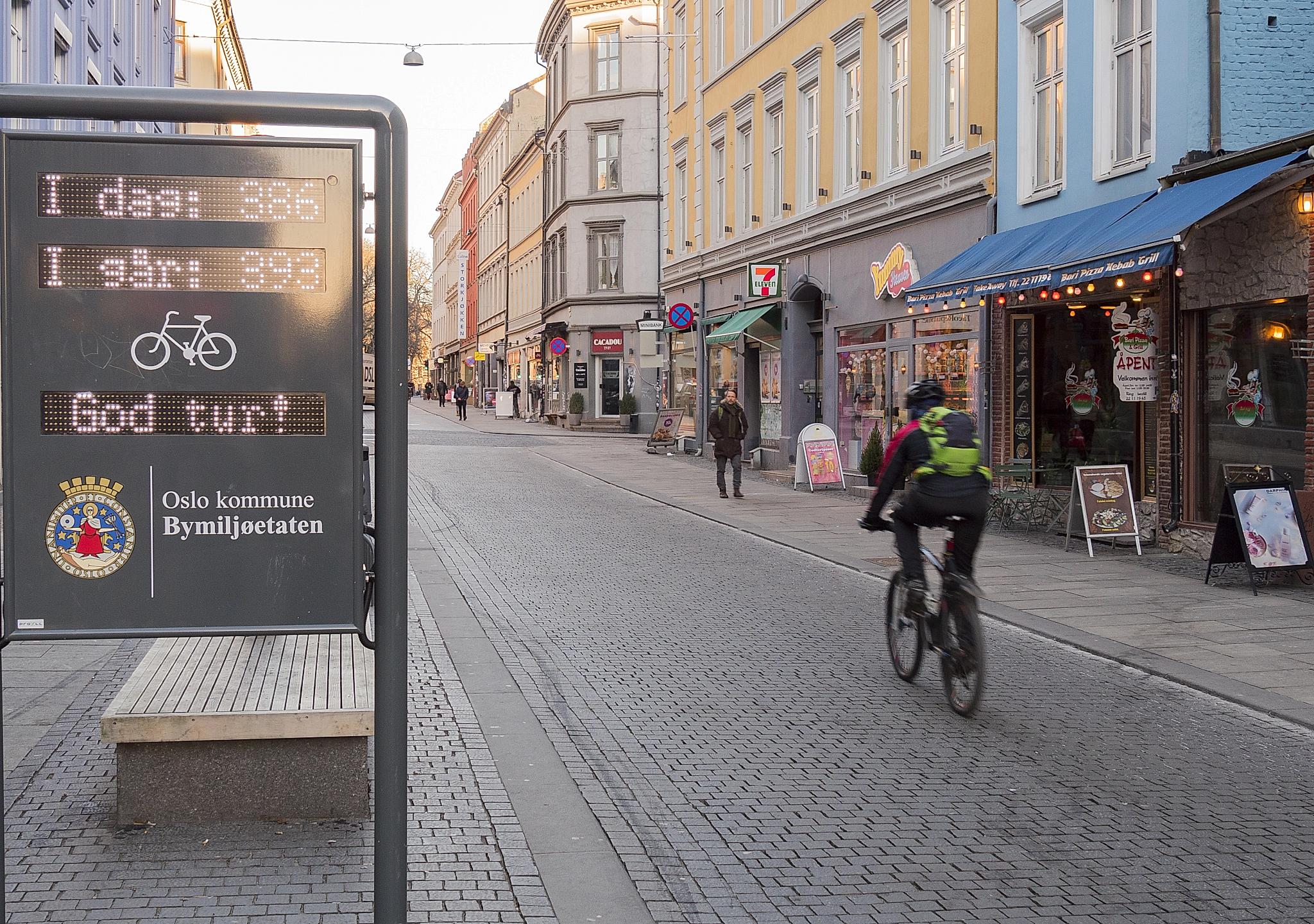 A person cycling past a sign that registers passing bikes