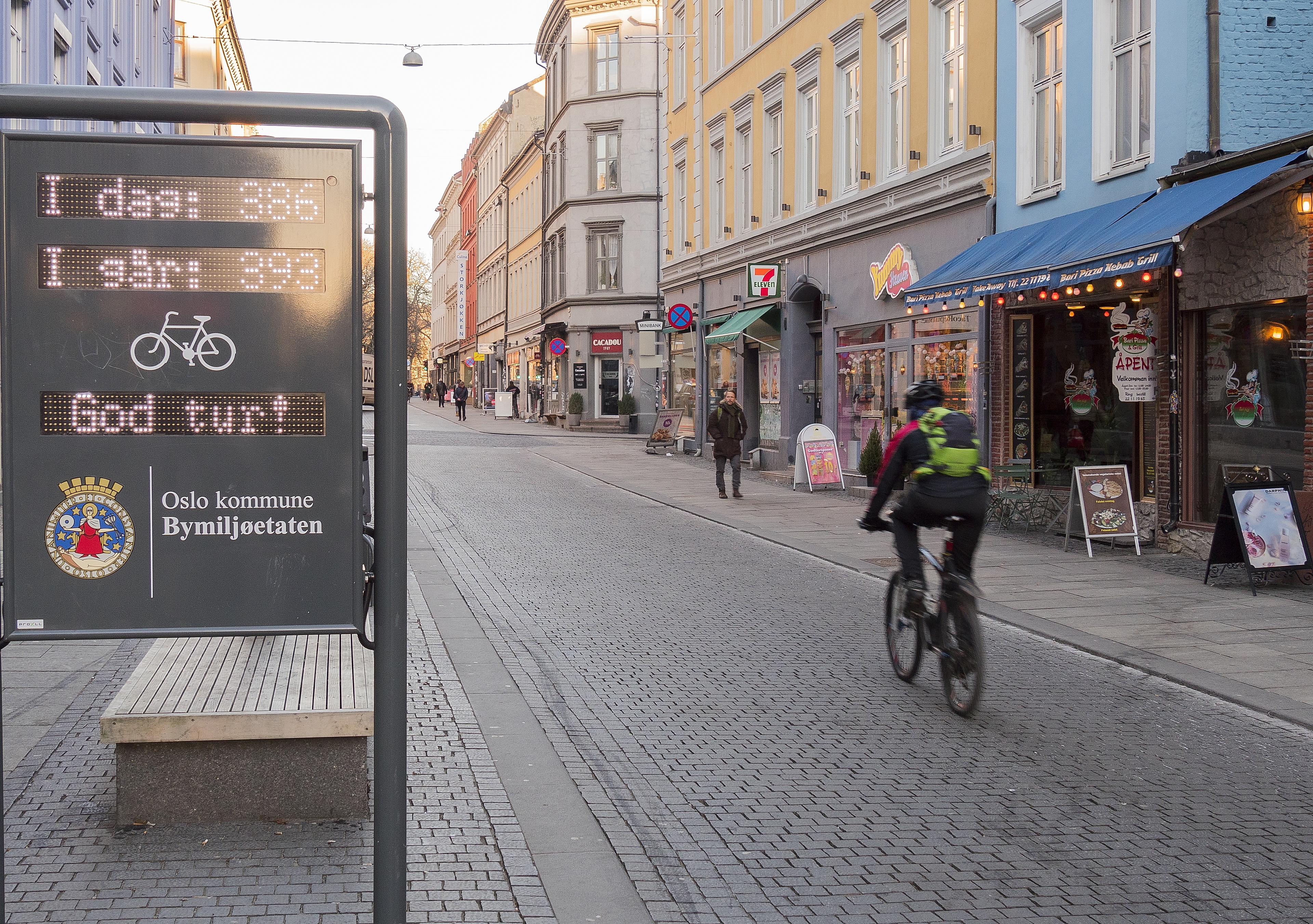 A person cycling past a sign that registers passing bikes