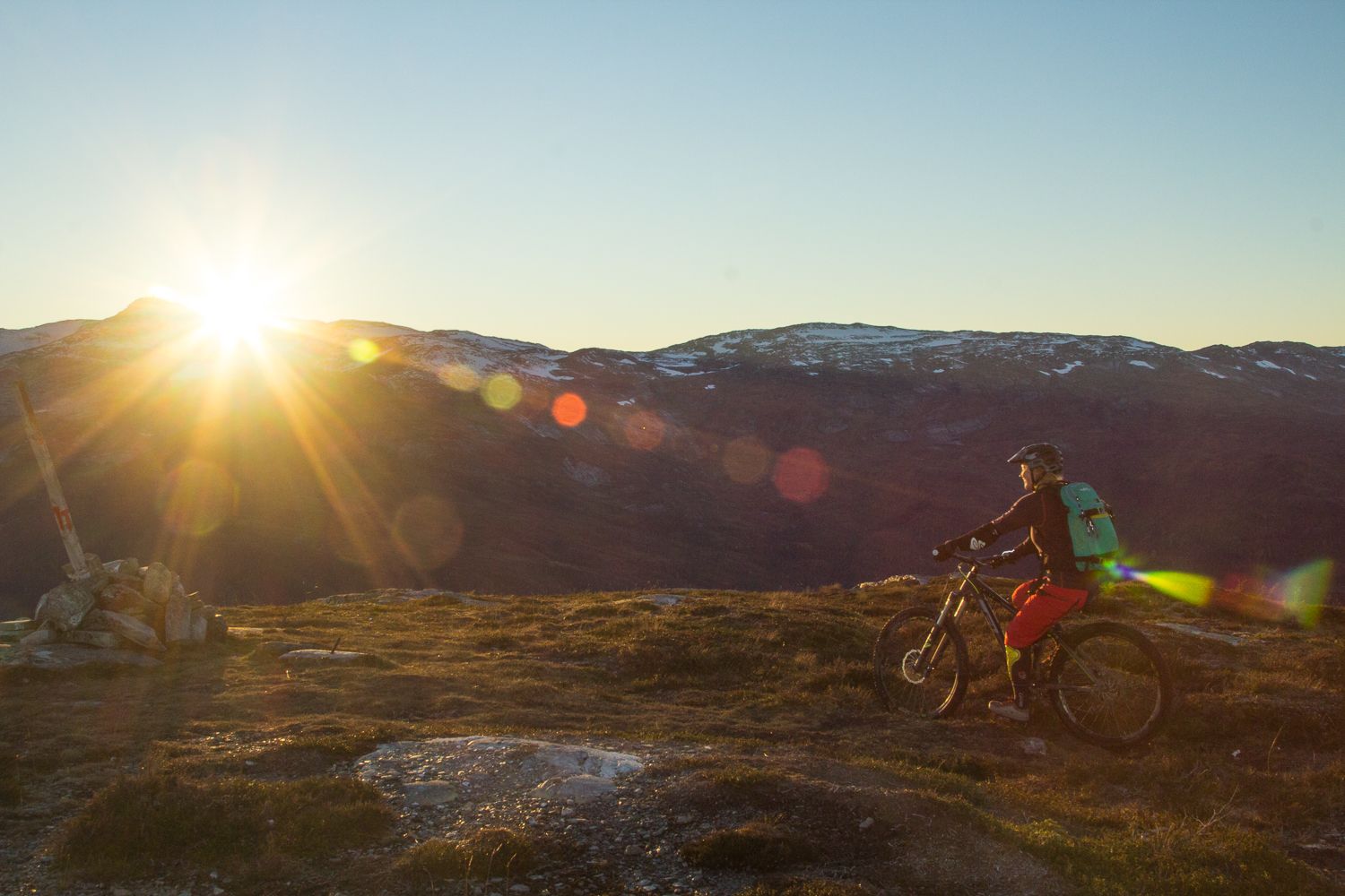 A woman mountain biking in sunset, Voss in Fjord Norway