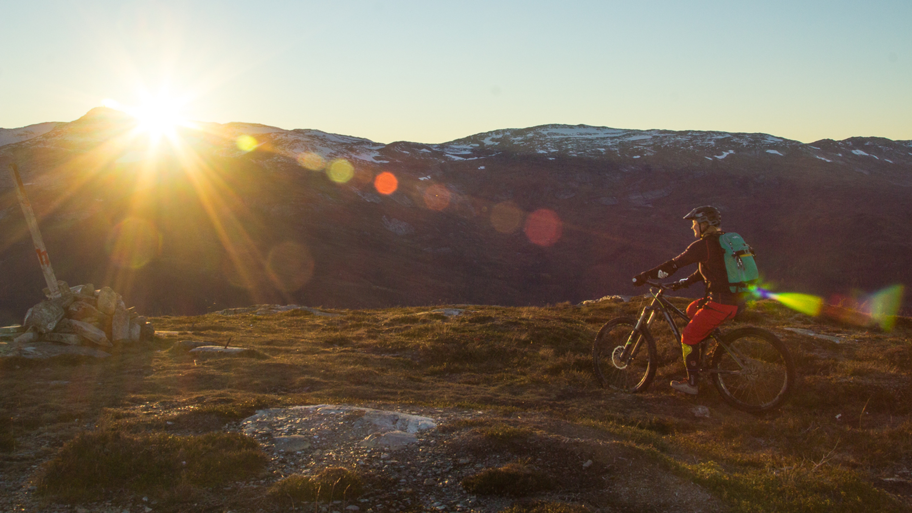 A woman mountain biking in sunset, Voss in Fjord Norway