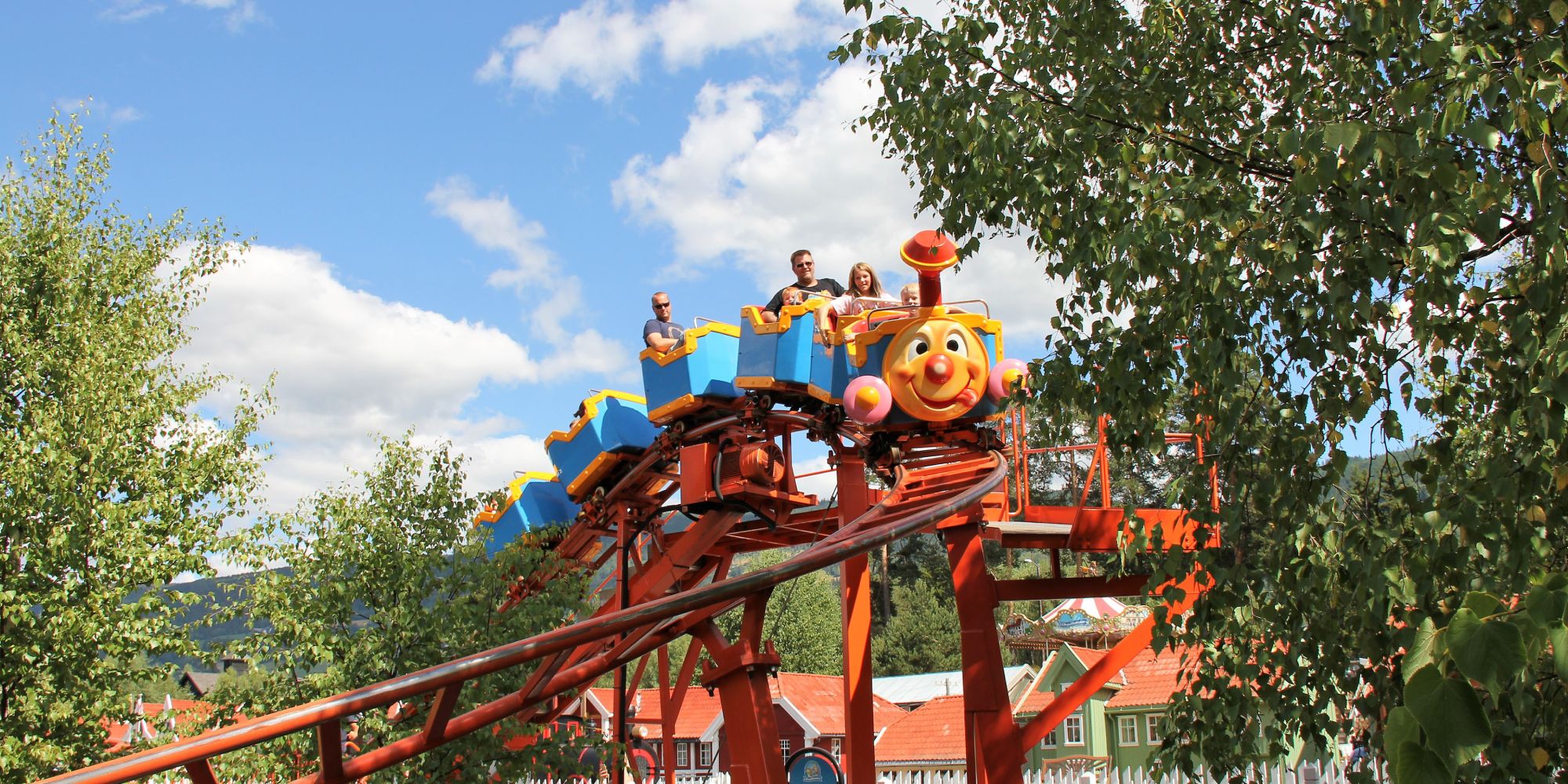 A family riding a carousel in Lilleputthammer amusement park, Norway