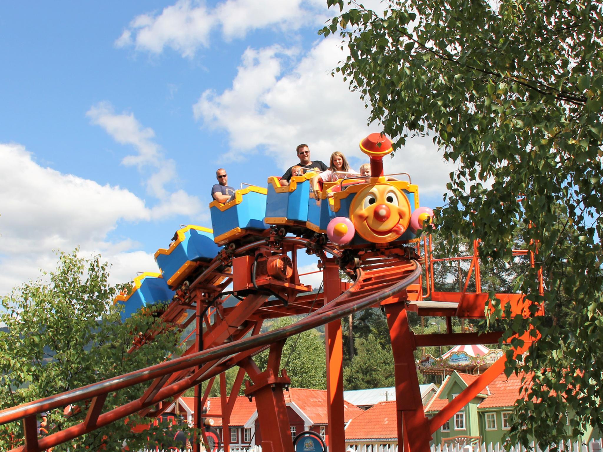 A family riding a carousel in Lilleputthammer amusement park, Norway