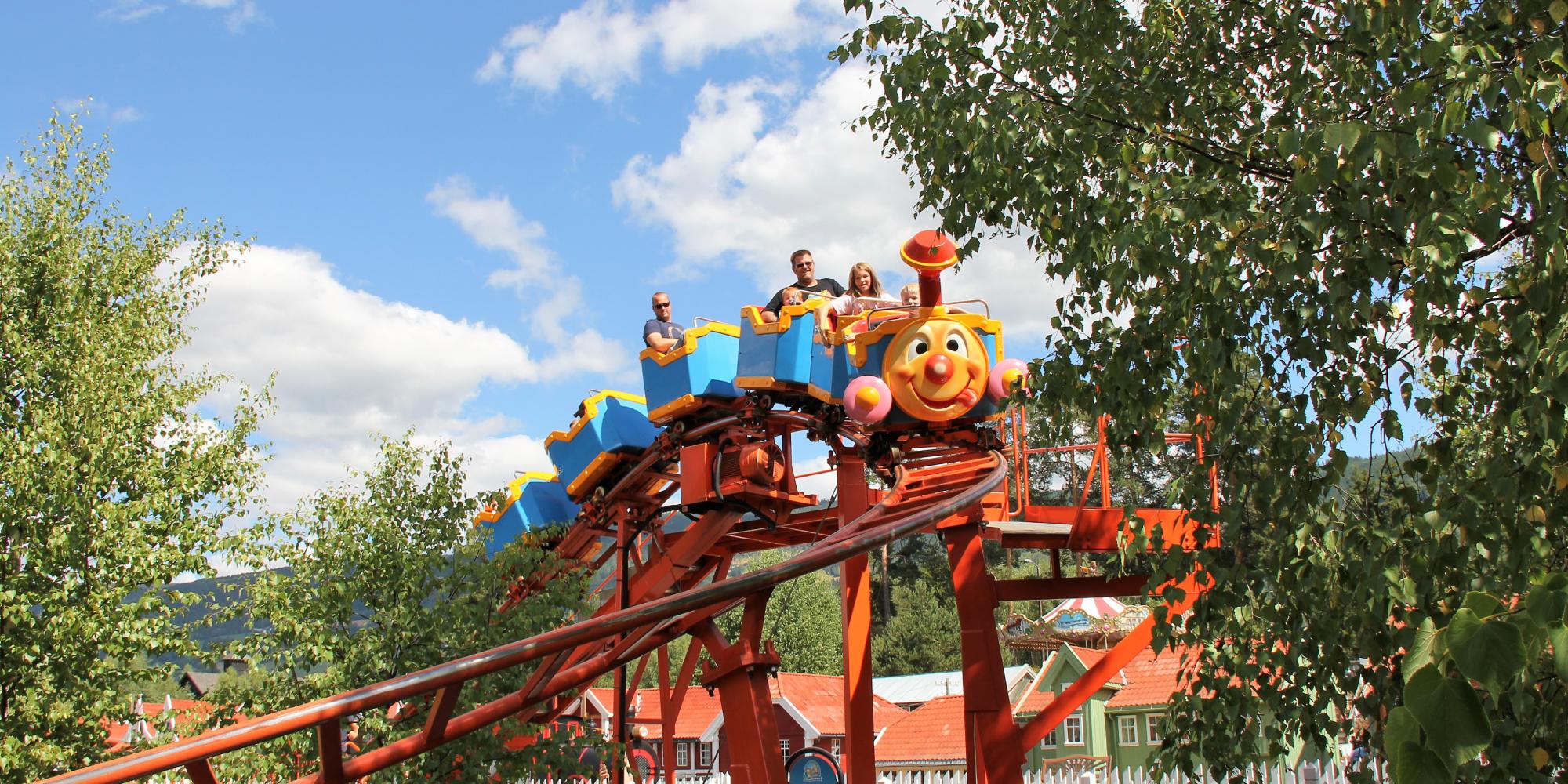 A family riding a carousel in Lilleputthammer amusement park, Norway