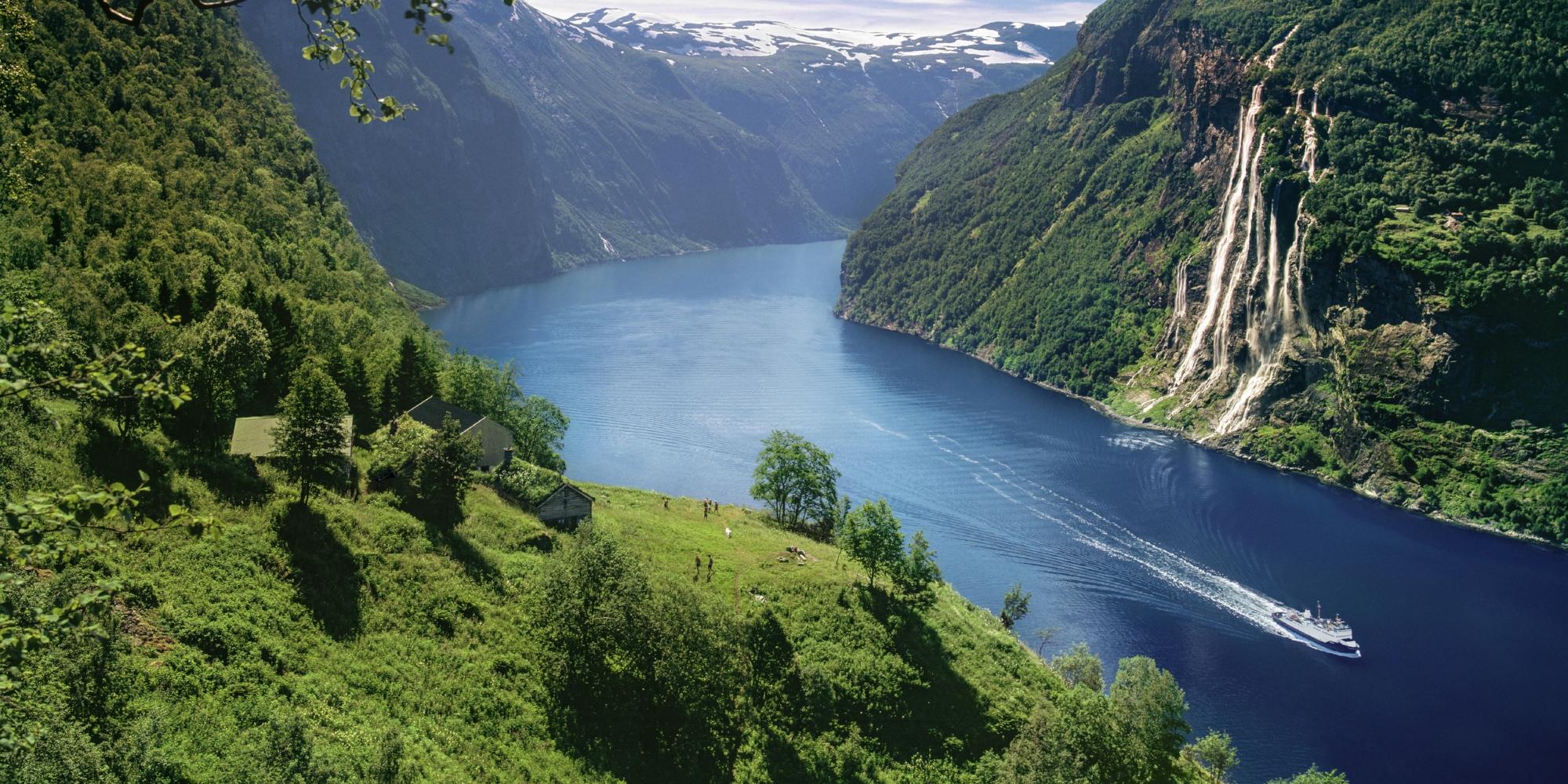 A boat cruising on the Geirangerfjord in Norway on a sunny summer day