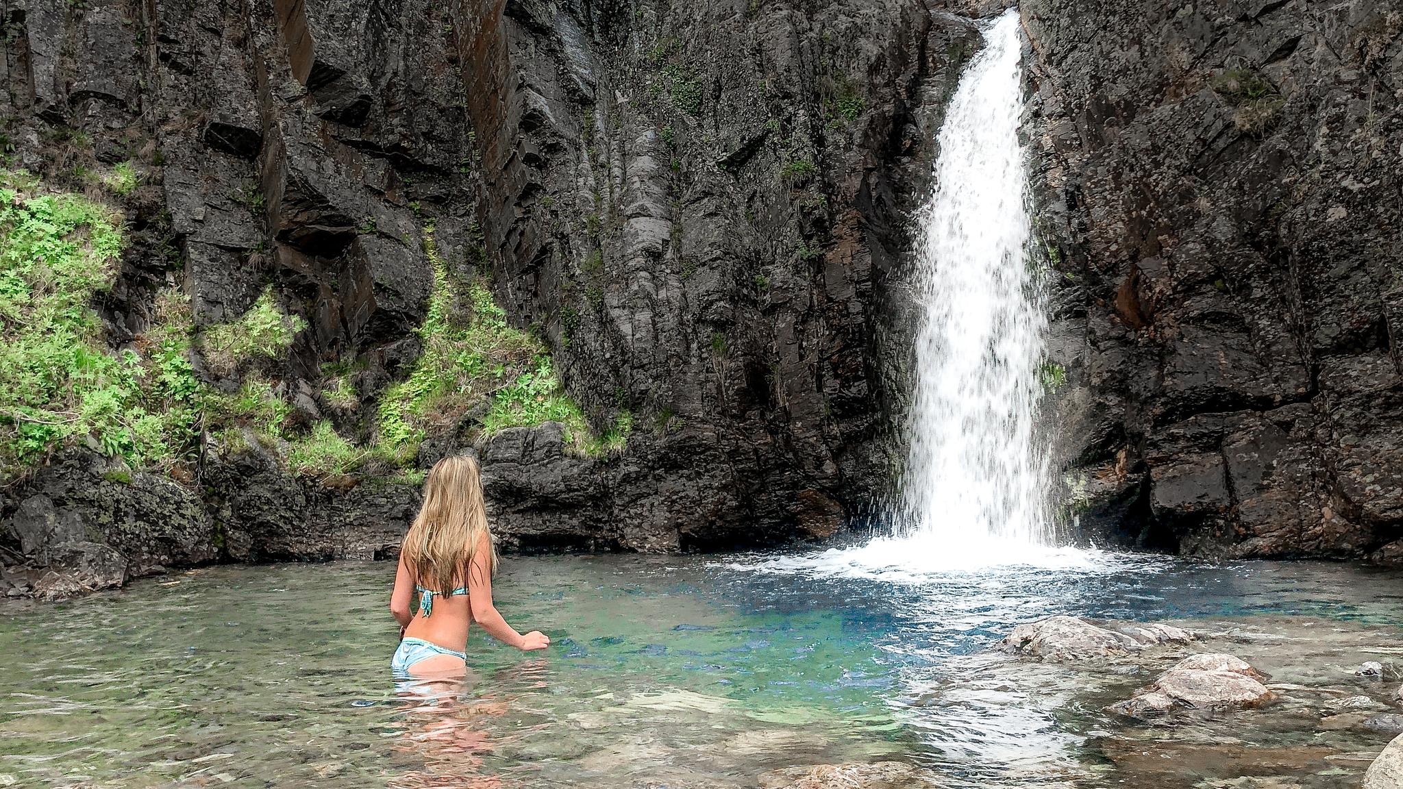 En dame bader nedenfor en foss i Hemsedal på Østlandet