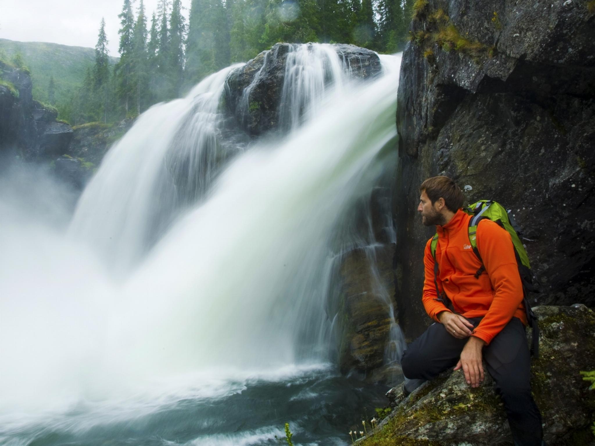 Un escursionista guarda la cascata Rjukandefossen a Hemsedal