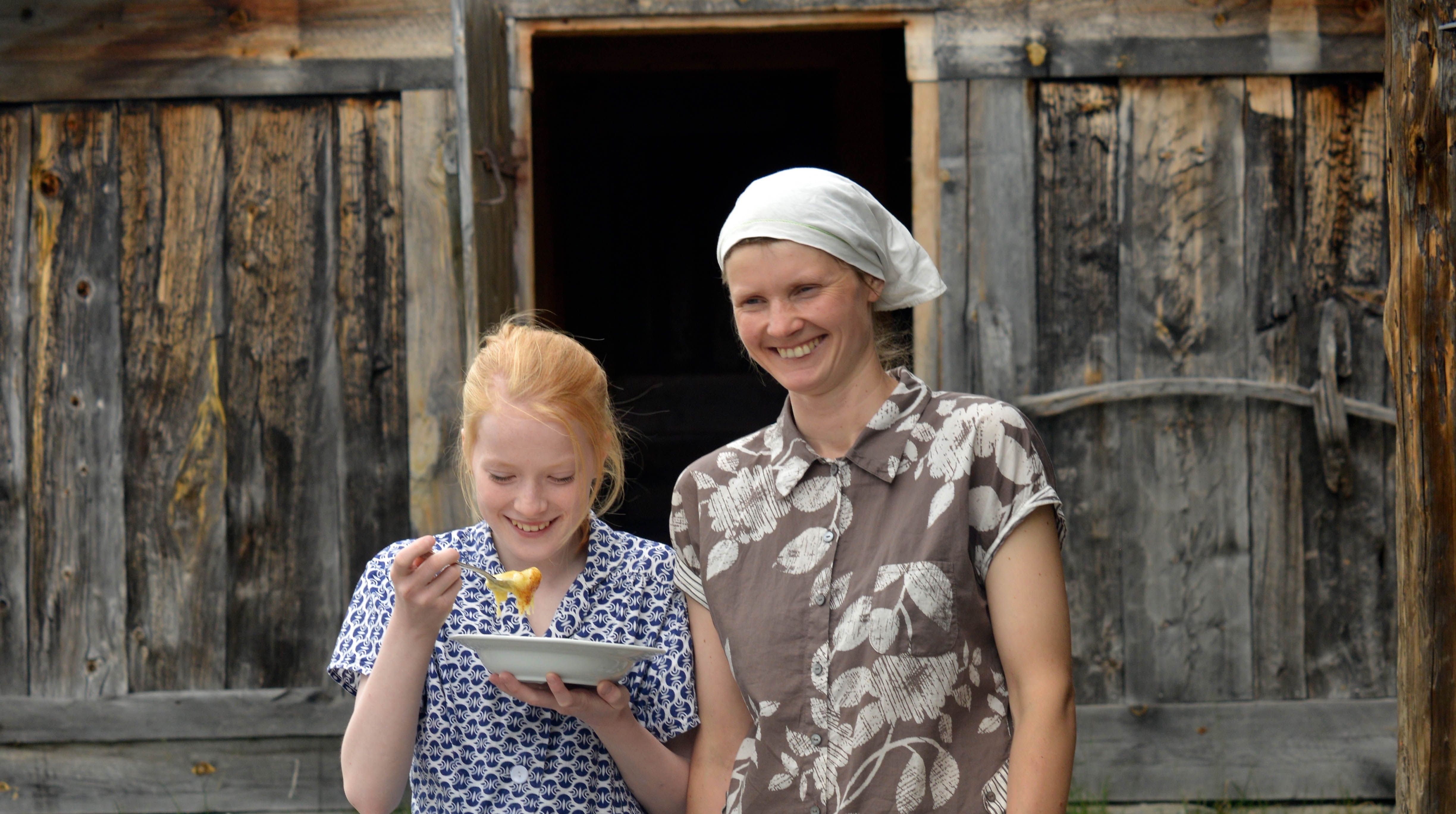 Zwei Frauen essen Rømmegrøt (Sauerrahmbrei) in Rjukan in der Telemark, Ostnorwegen