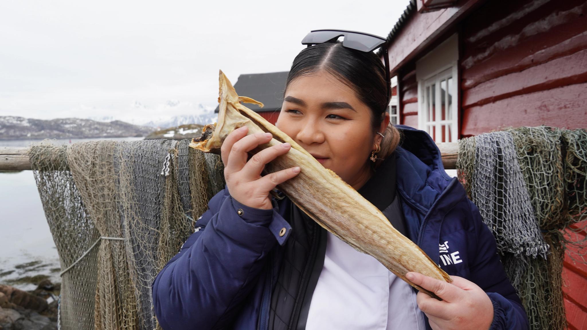 Asian looking woman smelling stockfish