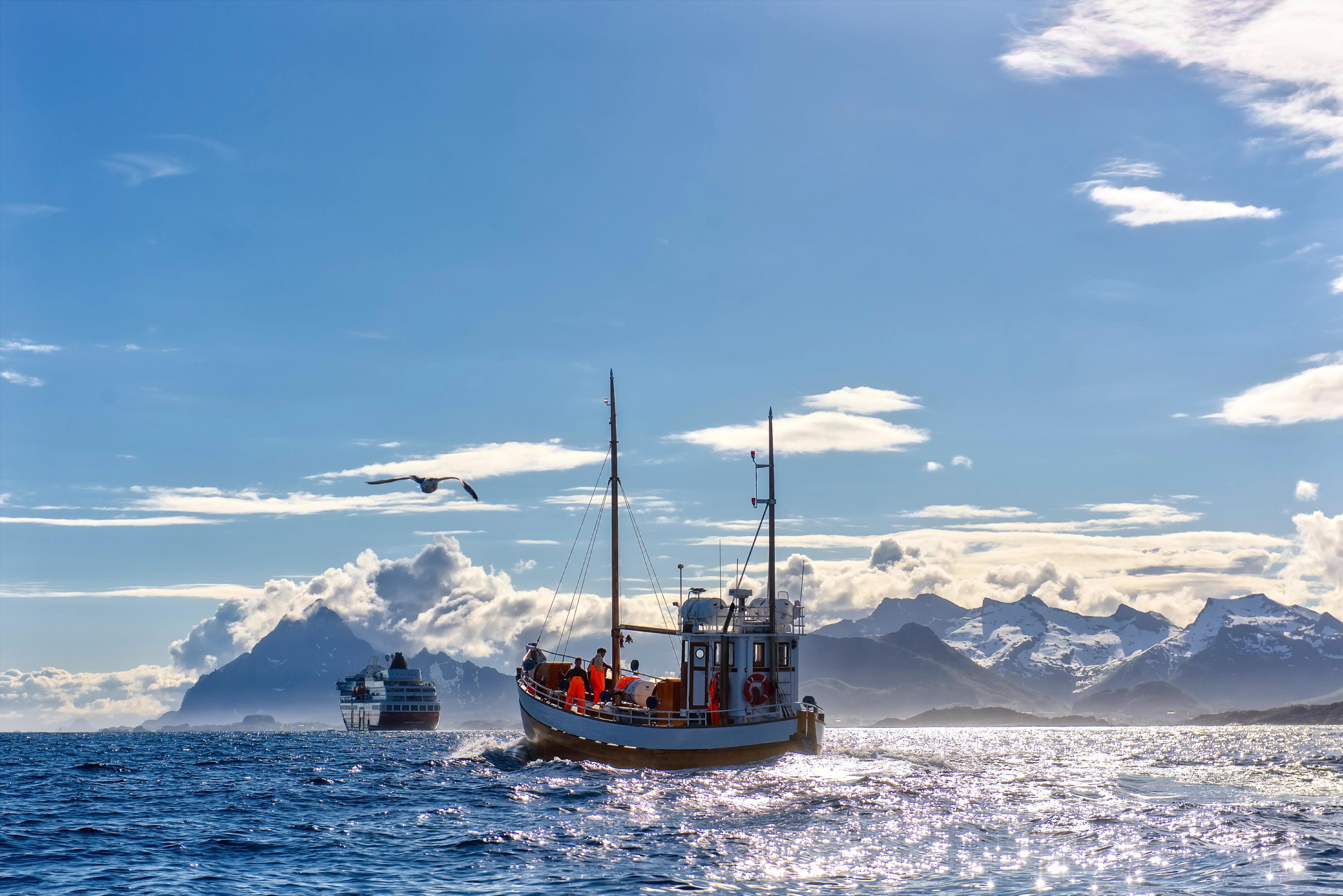 A fishing boat in front of a Hurtigruten ship in Northern Norway